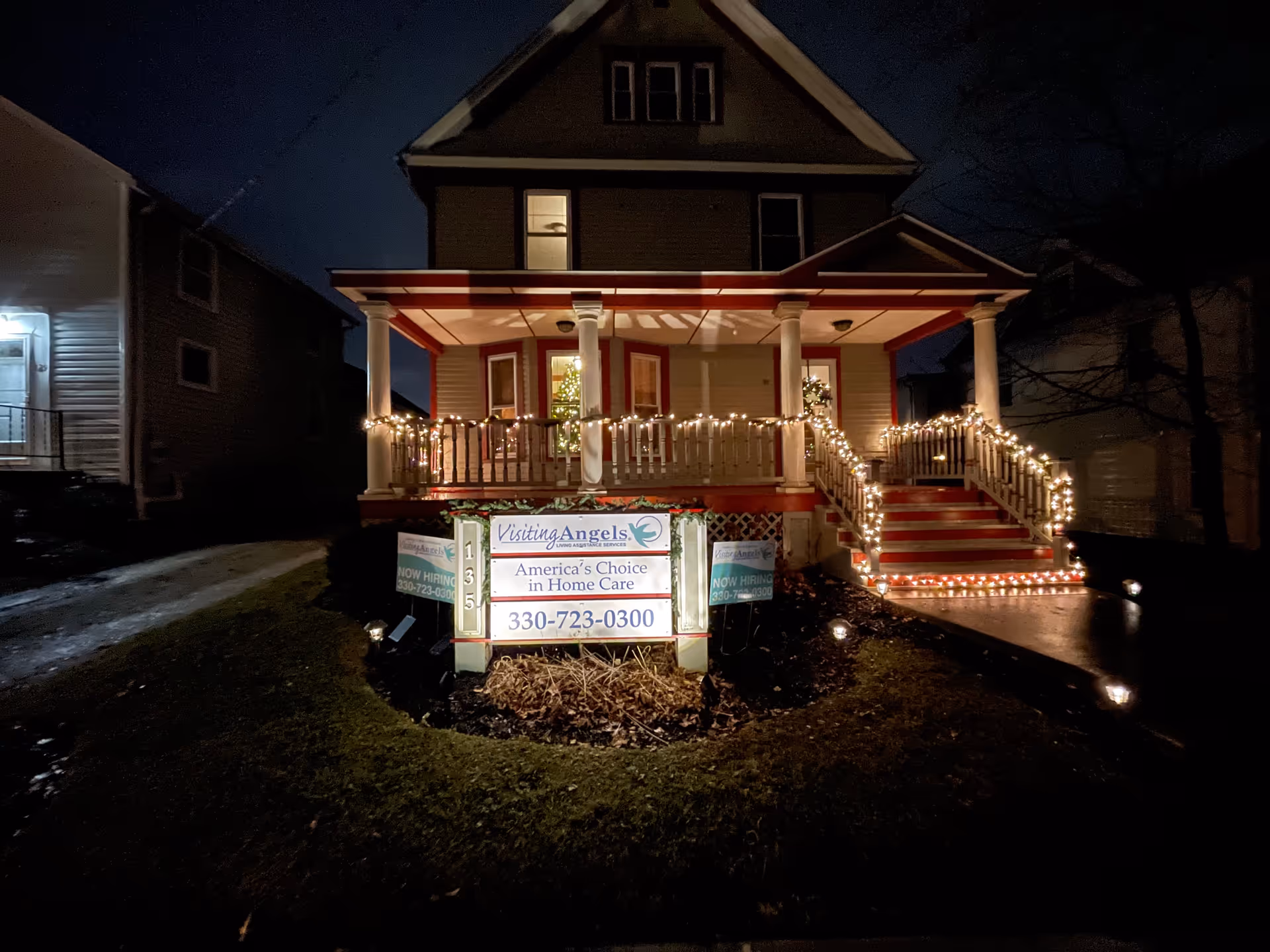 Night exterior of Visiting Angels Senior Home Care building with illuminated porch and lights