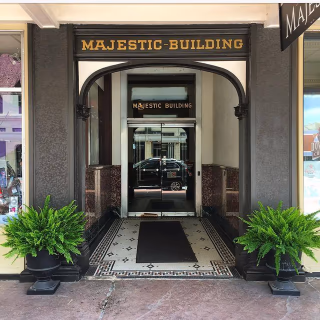 Entrance to Majestic Building with arched doorway and potted ferns.