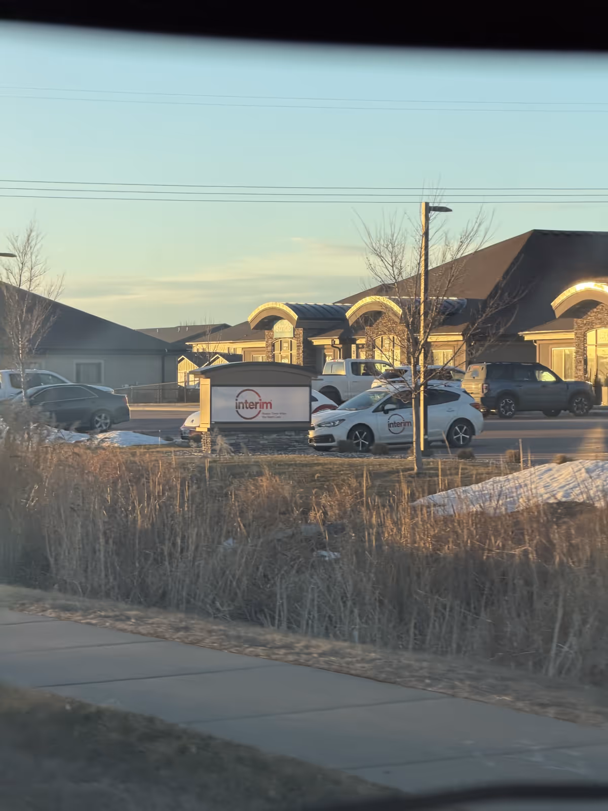 Exterior view of Interim HealthCare of Sioux Falls facility with parked cars