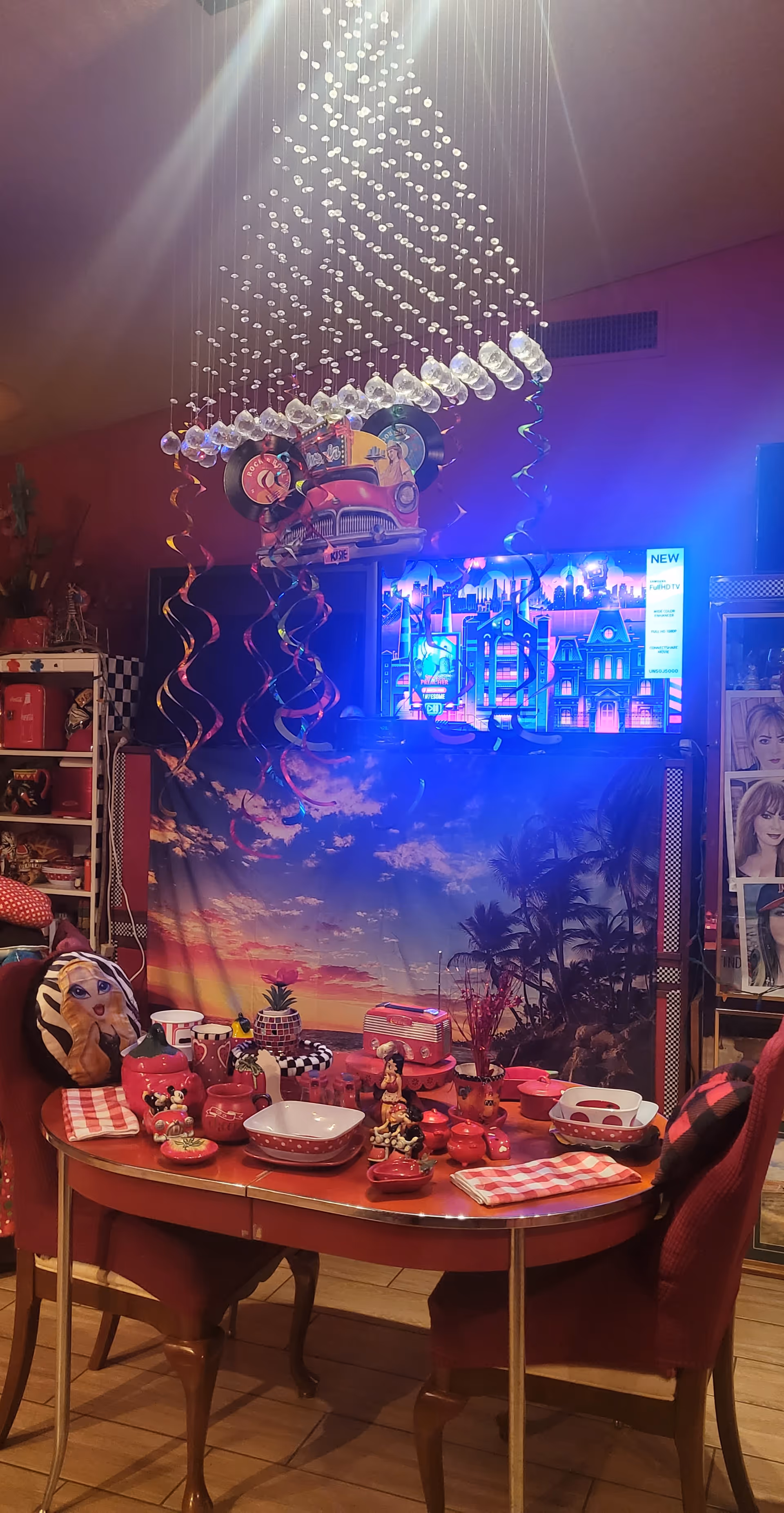 Decorated dining room with a round table set for a party and a colorful backdrop.