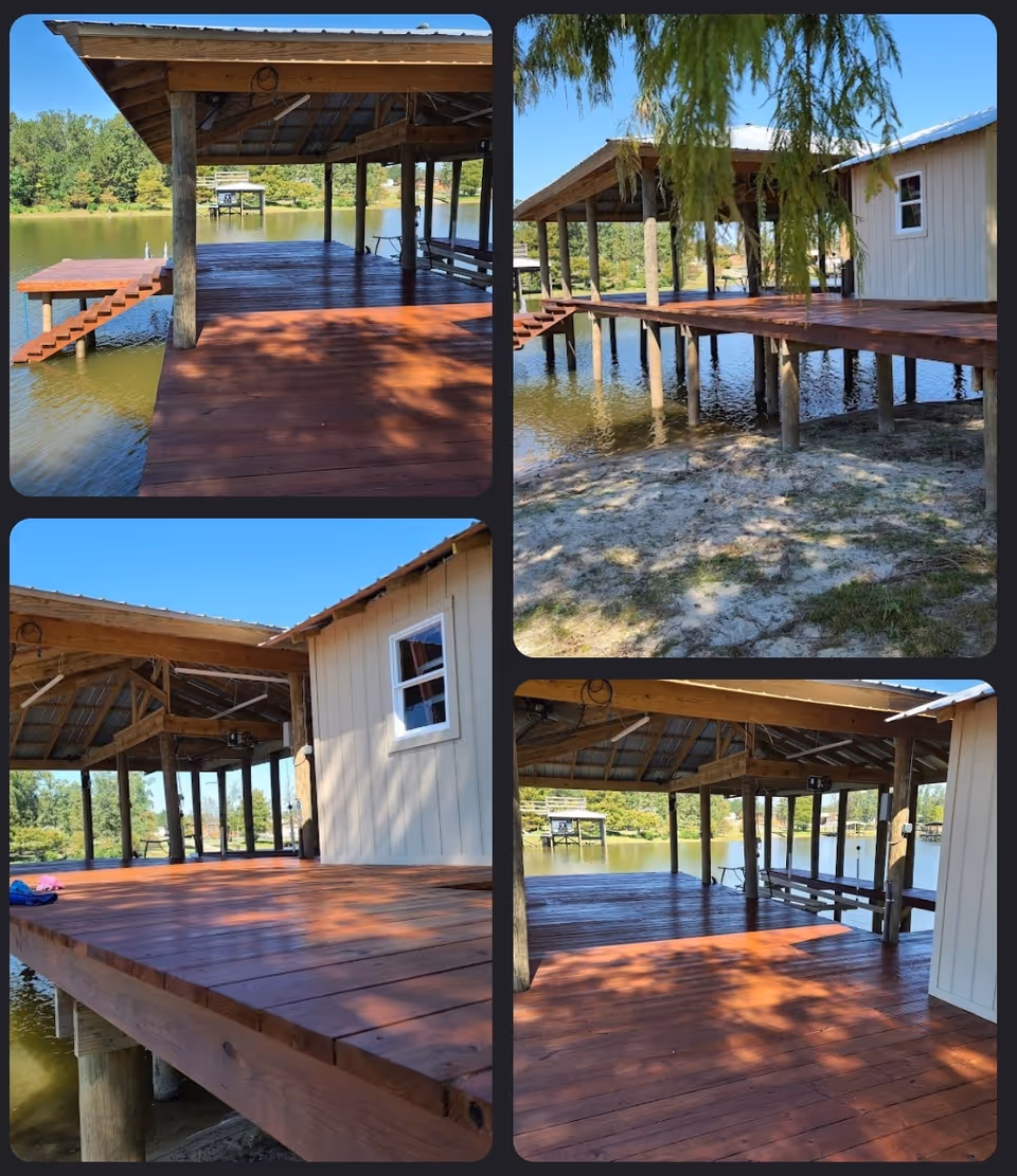 Wooden dock and covered pavilion extend over a lake beside a small building