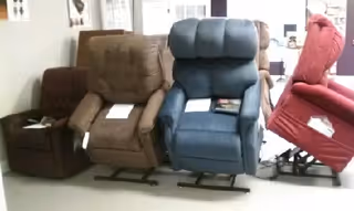Three recliner chairs lined up in an indoor showroom.