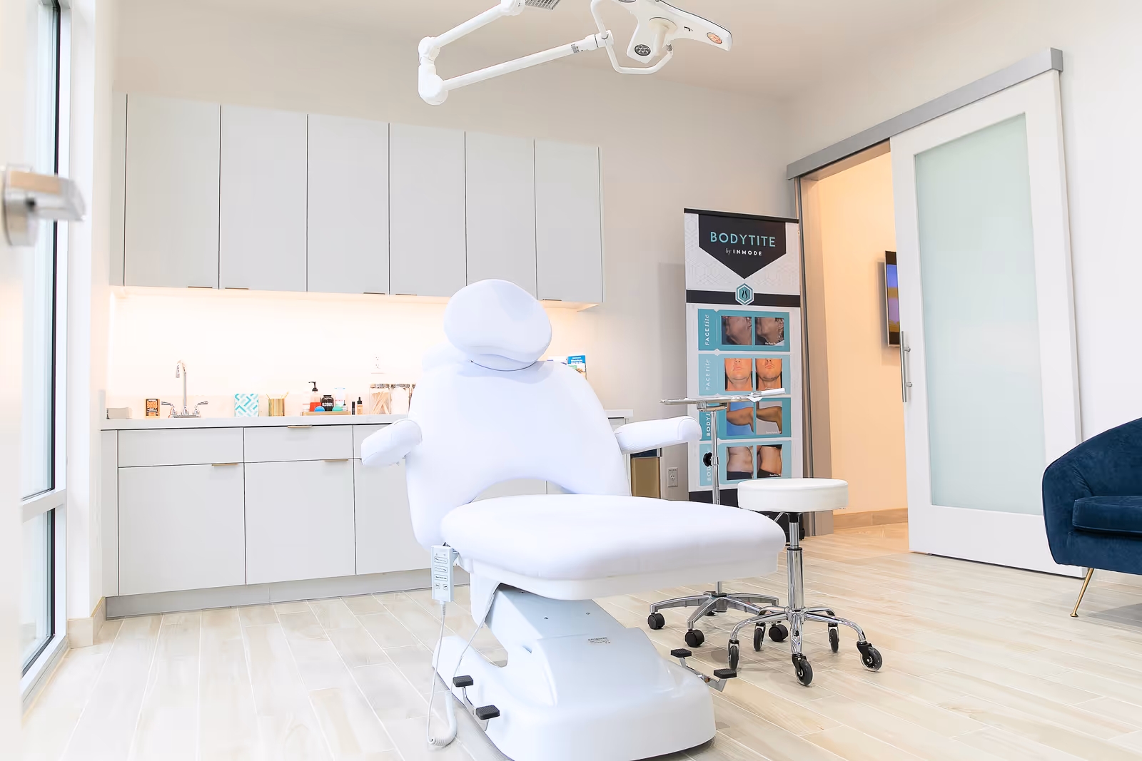Bright, modern medical treatment room with a white reclining chair and cabinets.