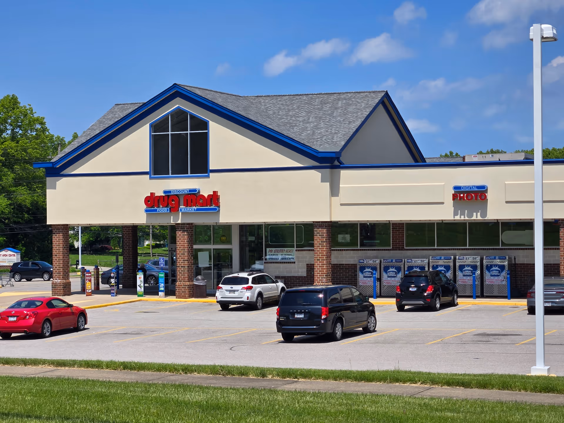 Front view of Discount Drug Mart storefront with a parking lot and blue sky.