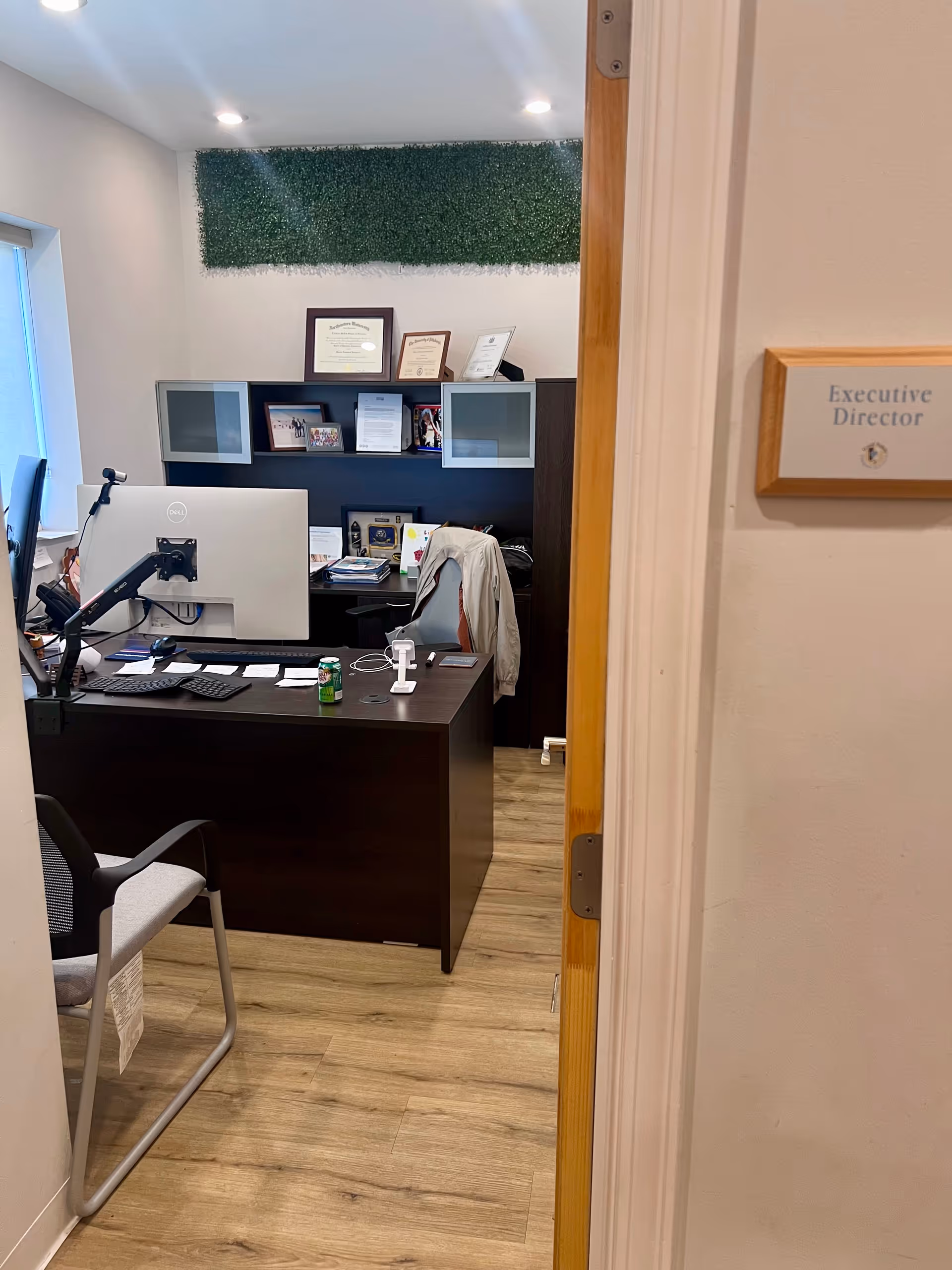 Office reception area in Good Family Support Services with desk, computer, and certificates.