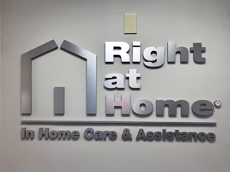 Interior wall sign featuring a house-shaped logo and 'Right at Home' branding.