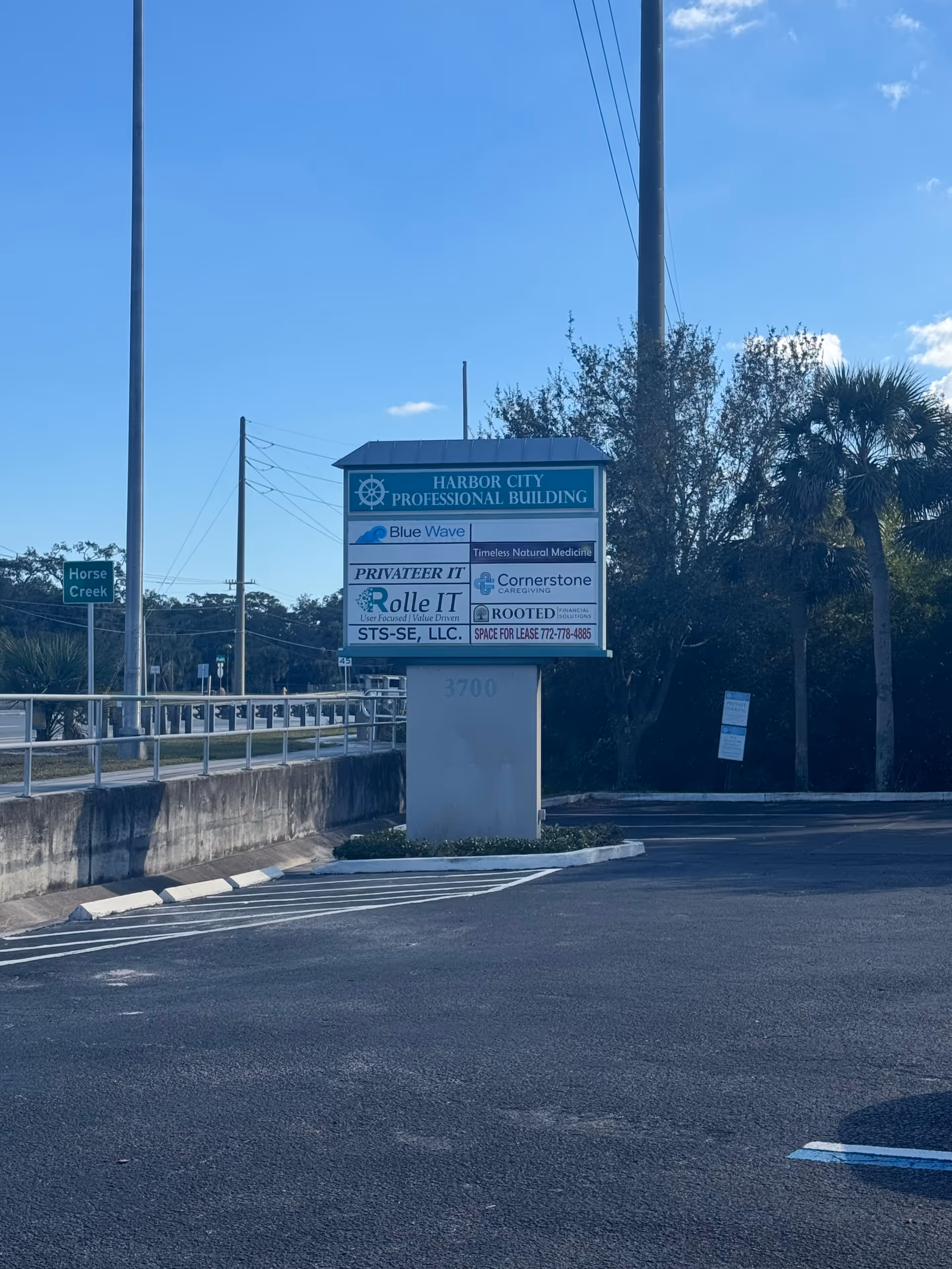 Freestanding Harbor City Professional Building sign in a parking lot.