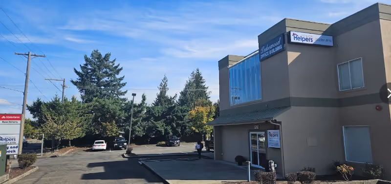 Exterior view of a Senior Helpers building with parking lot, trees, and blue sky