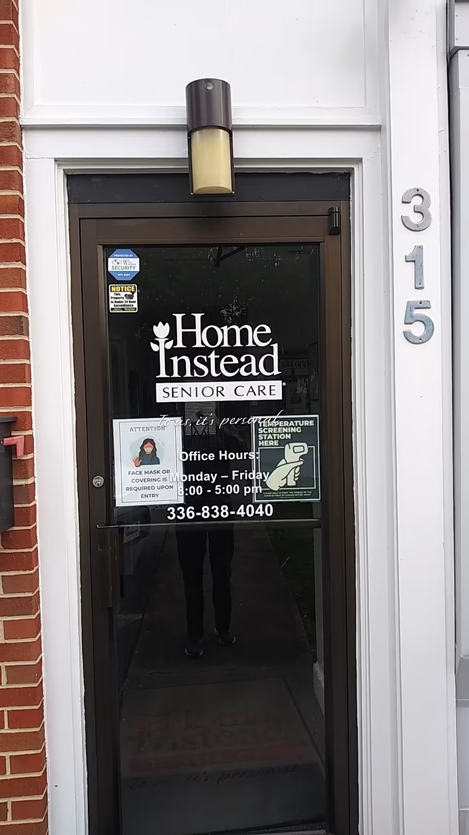 Glass door entrance for Home Instead Senior Care, with address 315 and hours displayed.
