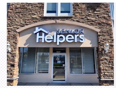 Front view of a Senior Helpers building entrance with stone facade and sign.