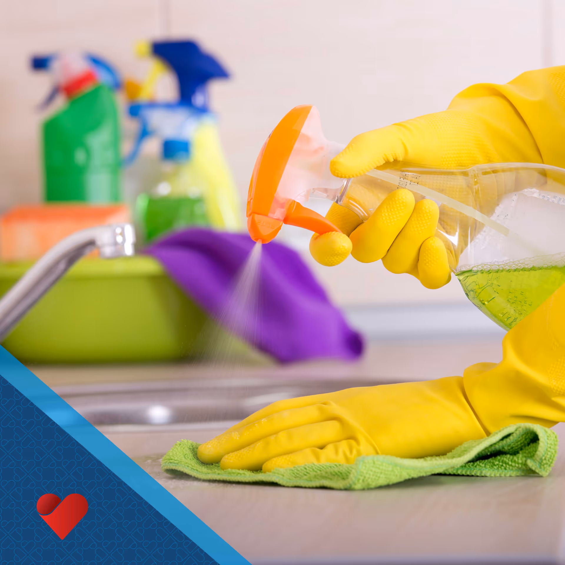 Close-up of gloved hands spraying cleaner and wiping a kitchen sink.