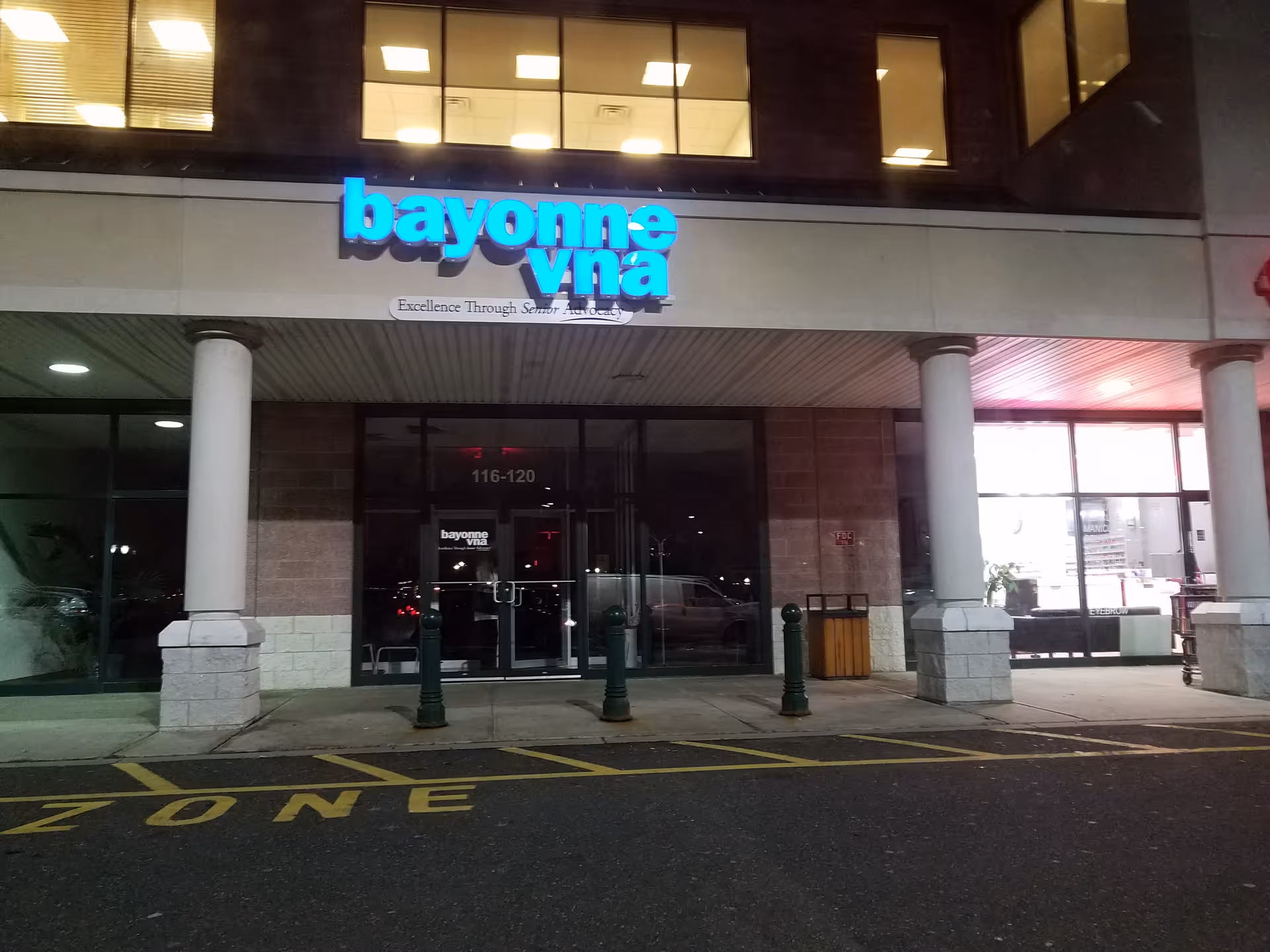 Exterior storefront with blue illuminated sign and glass entrance doors.