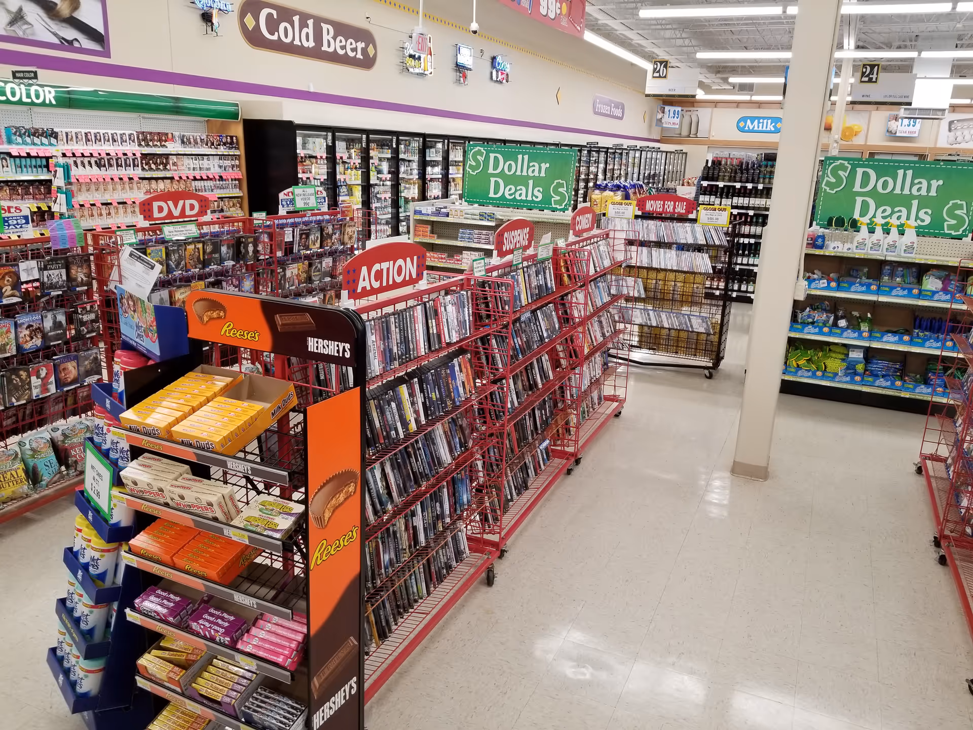 Bright store interior with magazines, DVDs, and snack displays on metal shelves.
