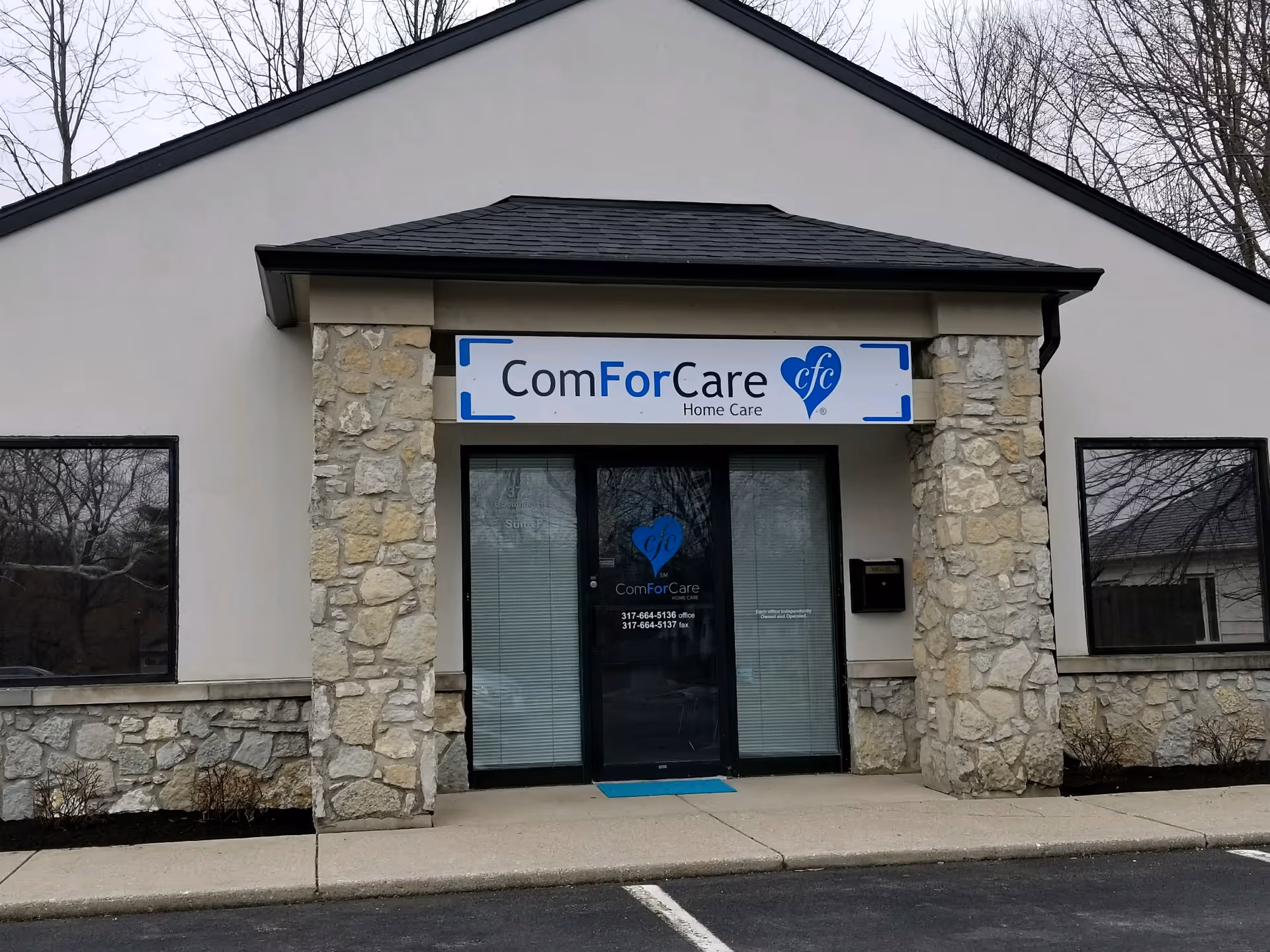 Front exterior of a ComForCare Home Care building with stone columns and glass entrance.