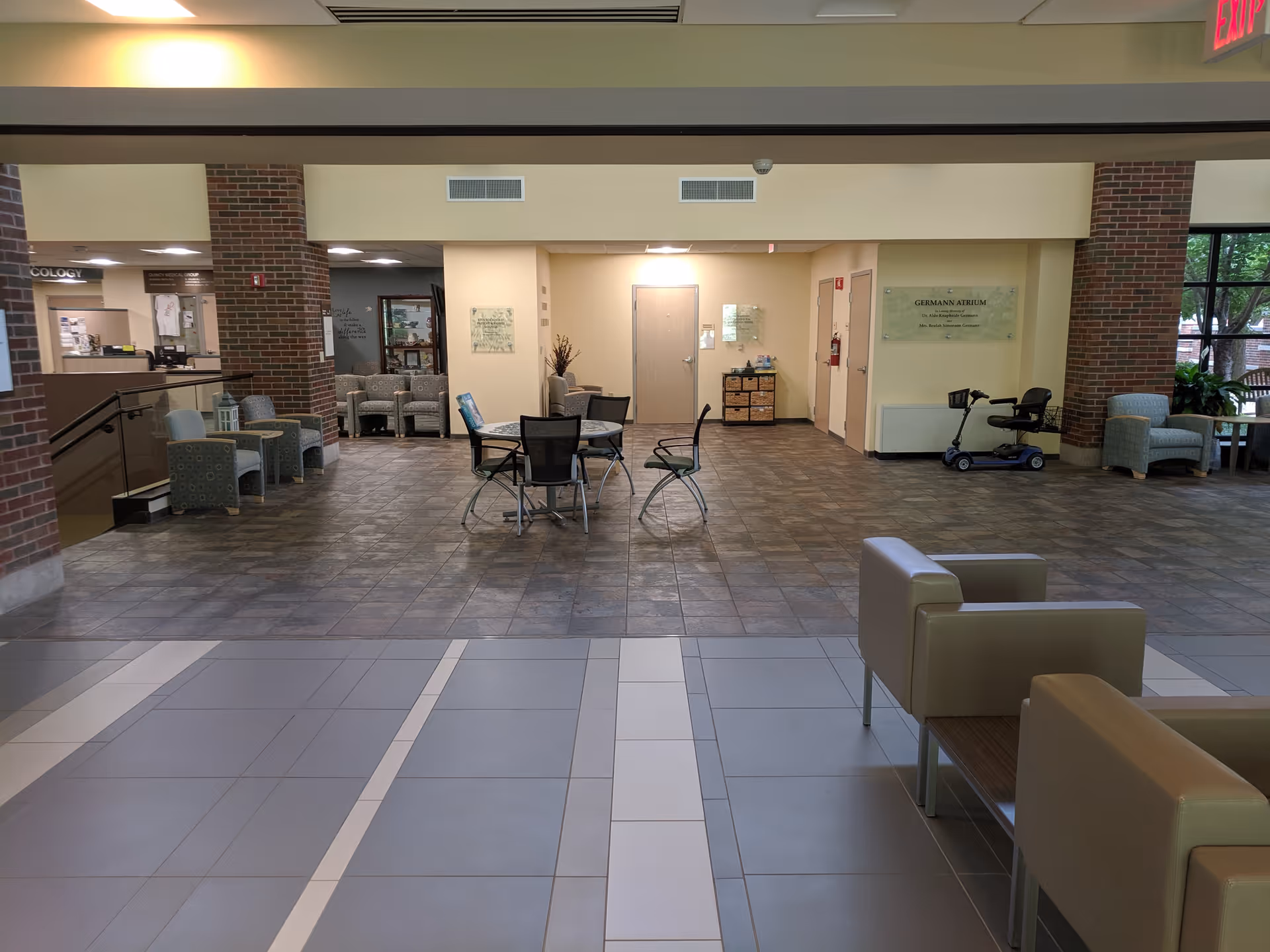 Interior lobby of Blessing Hospital with seating areas and brick columns.