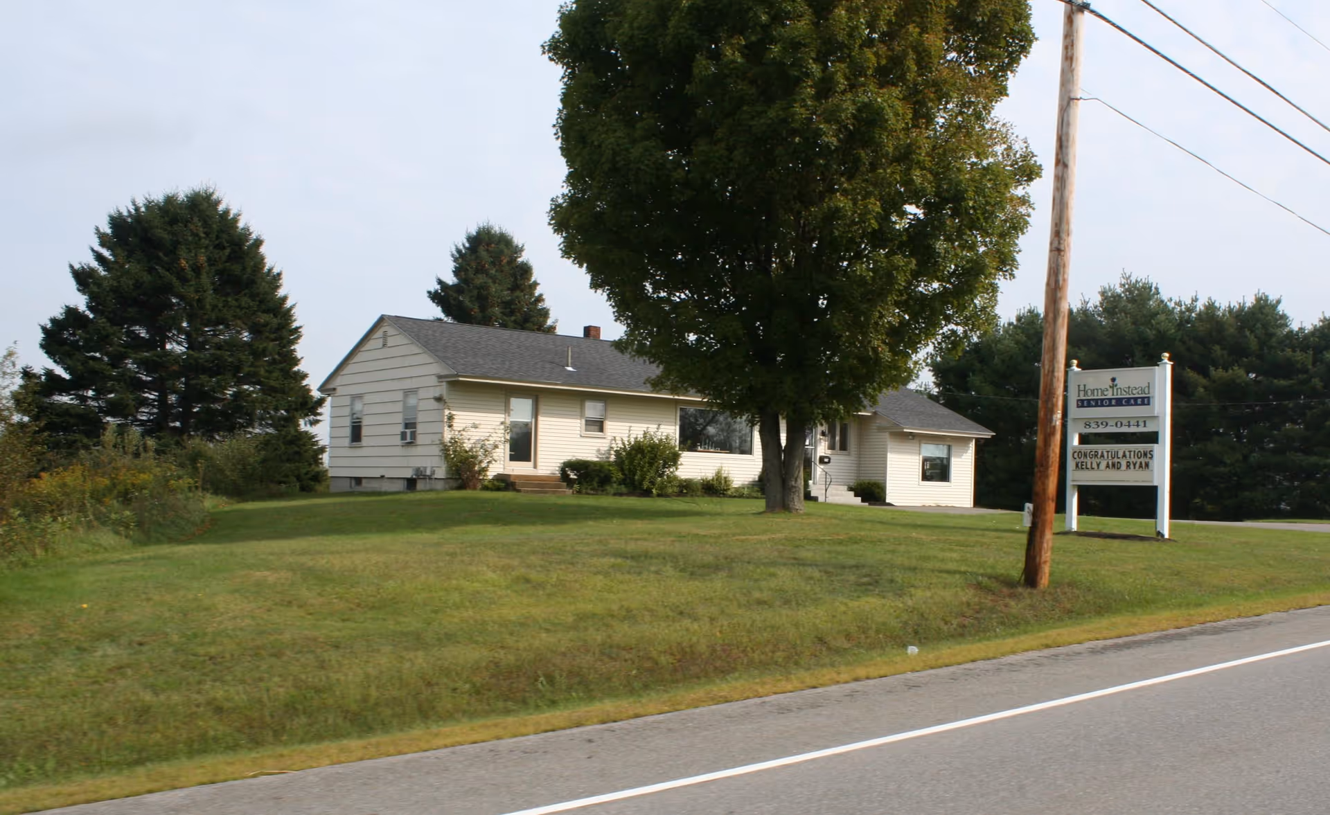 A single-story building with a Home Instead Senior Care sign on a grassy front lawn.