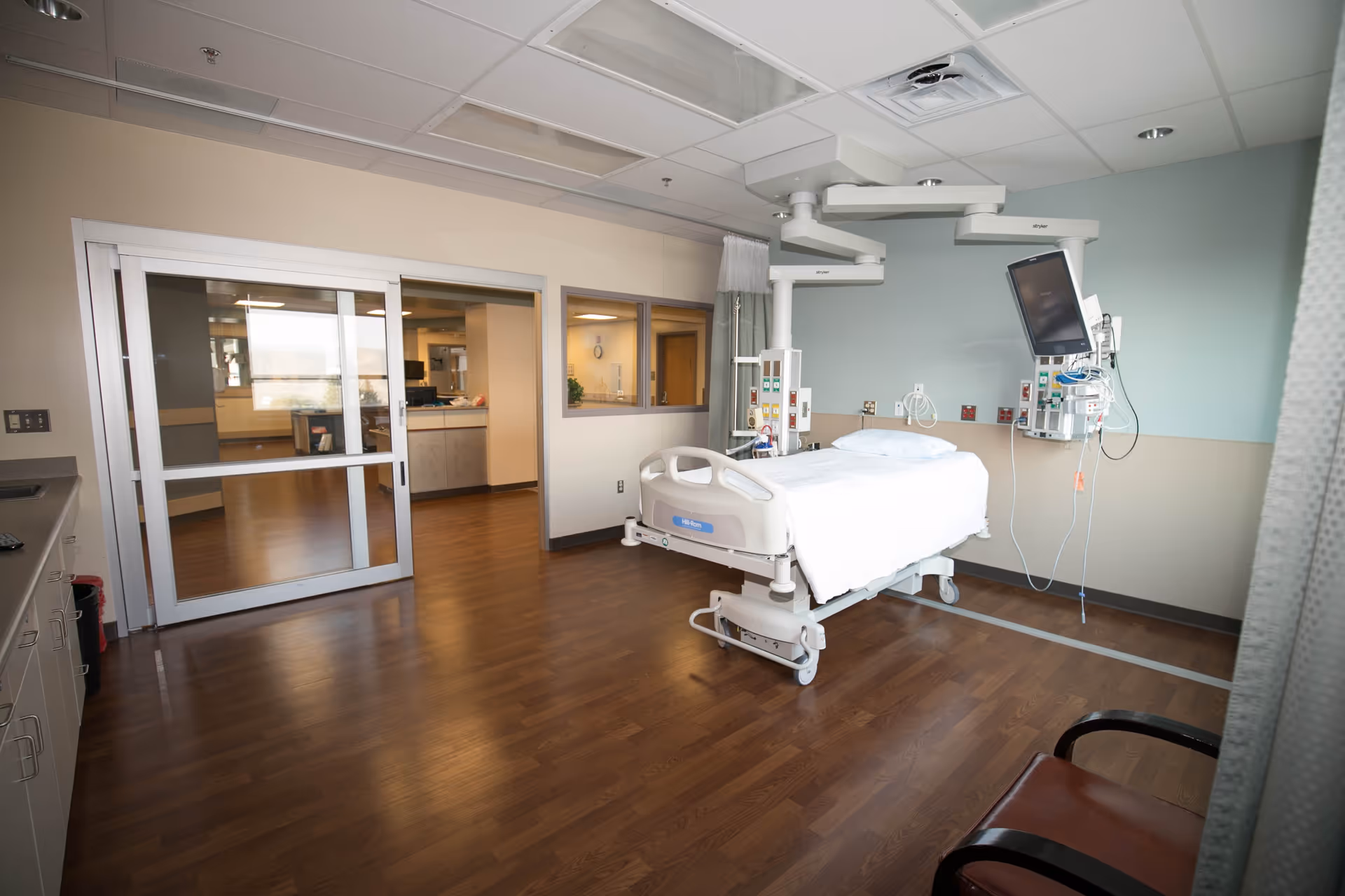 Hospital patient room with bed, monitors, and medical equipment.