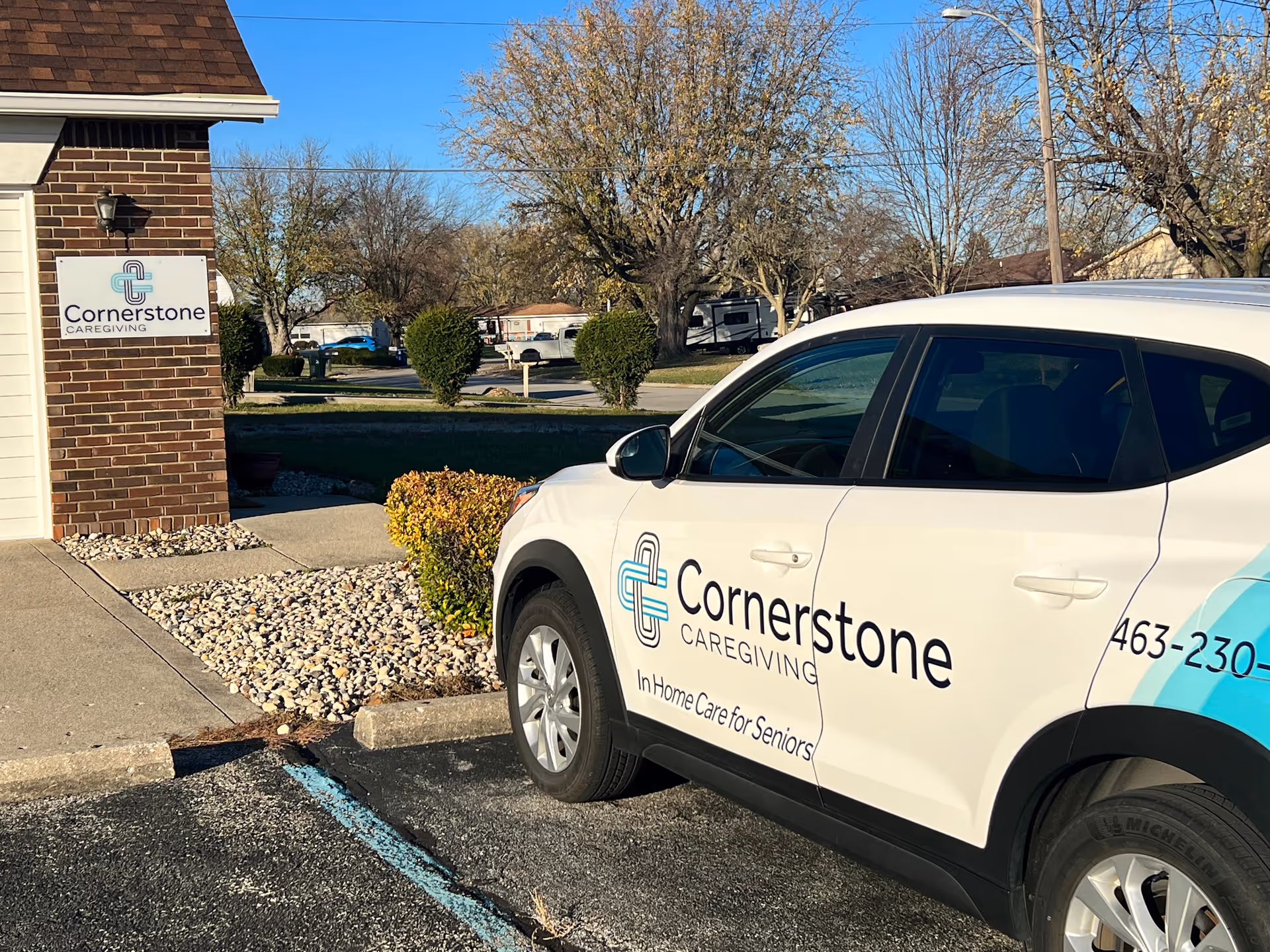 Cornerstone Caregiving van parked outside a brick building with signage.