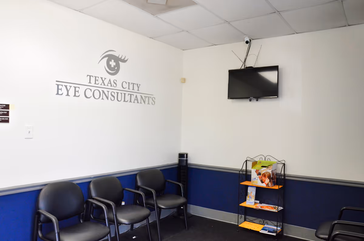 Waiting room at Texas City Eye Consultants with chairs, wall logo, TV, and magazine rack.