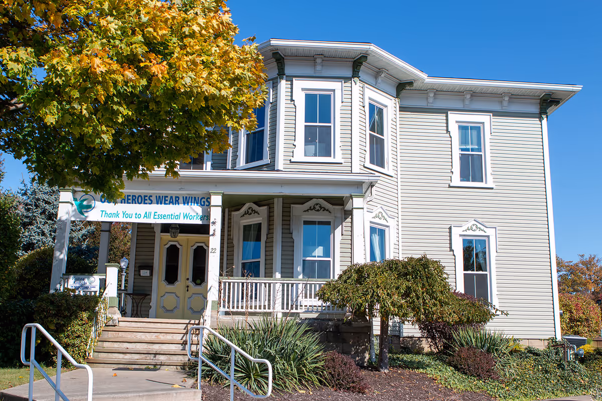 Two-story, house-style senior home with a banner on the front porch.