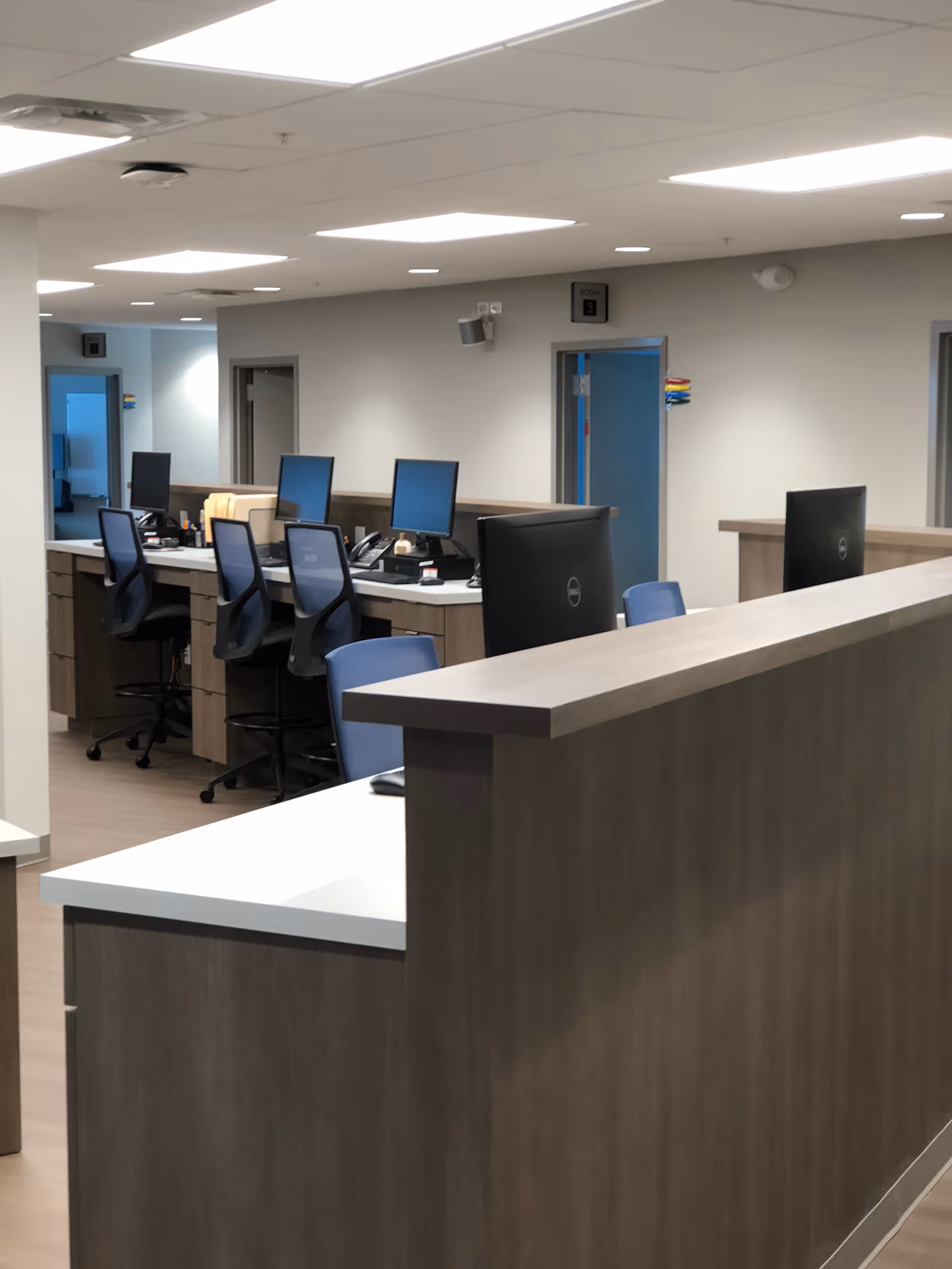Interior view of a reception area with computers and chairs.