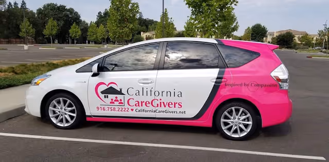 California CareGivers promotional car parked in a lot, white front and pink rear.