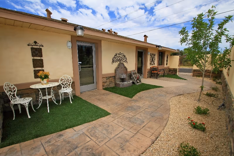 Outdoor courtyard at Americare Hospice & Palliative Care with seating and decorative walkways.