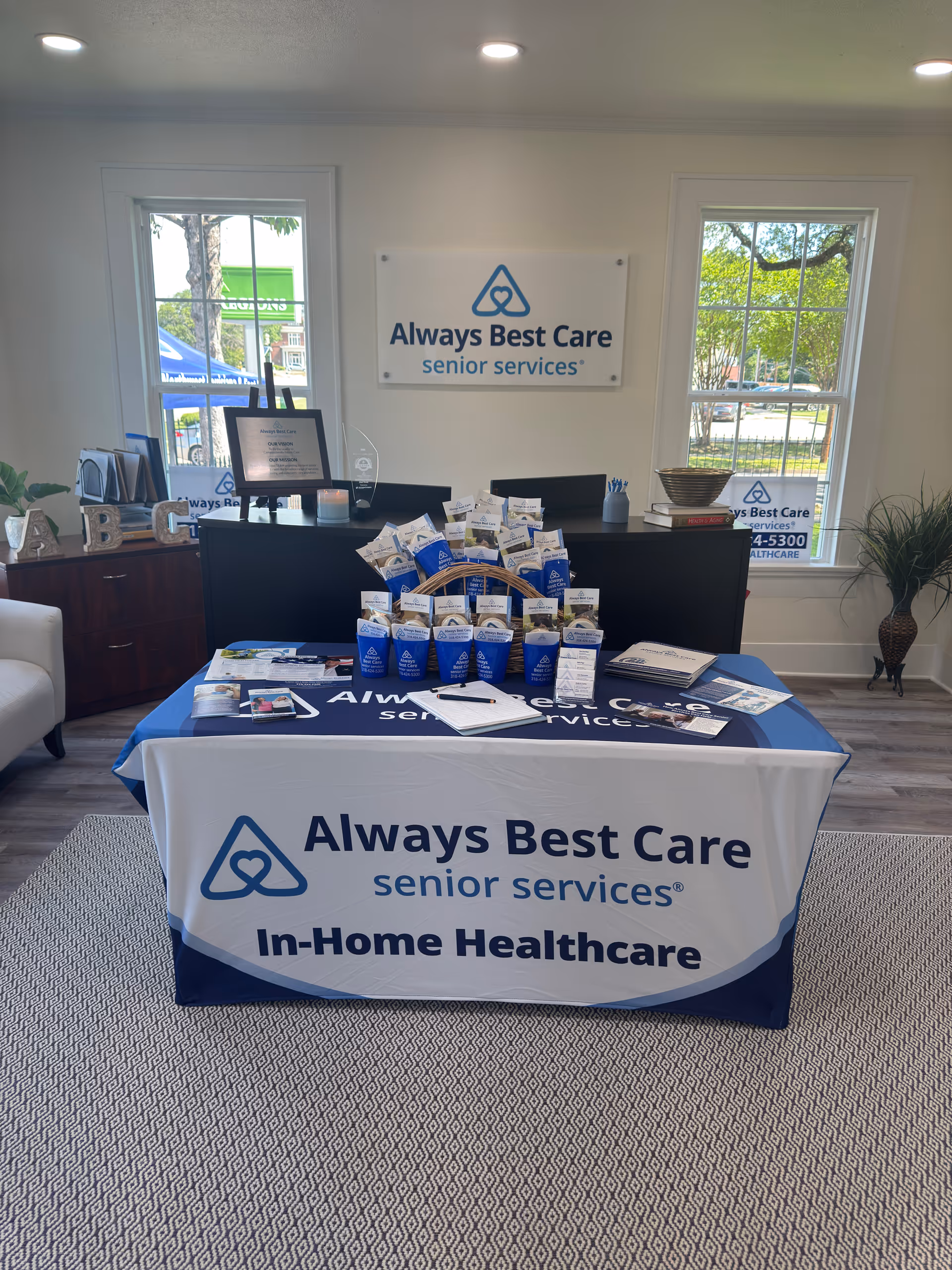Indoor reception area with Always Best Care signage, a brochure-filled table, and front desk.