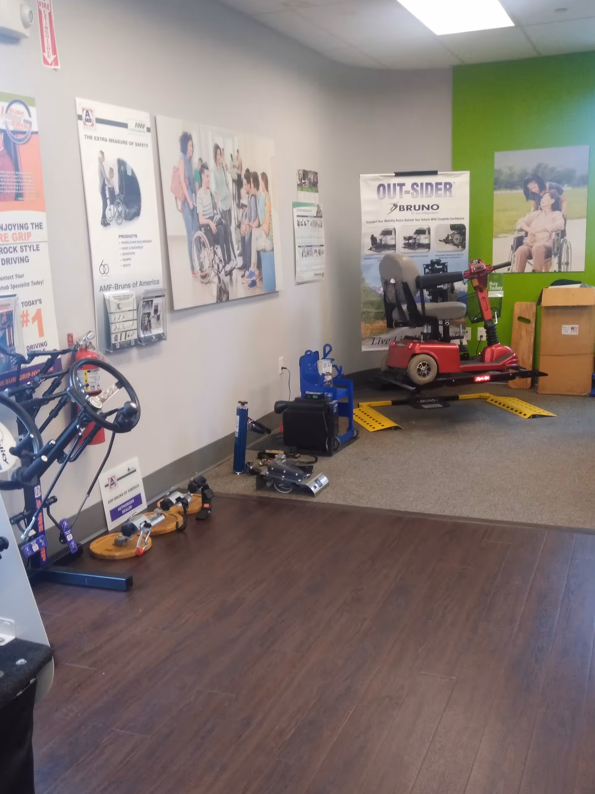 Indoor MobilityWorks showroom displaying mobility scooters, exercise equipment, and posters.