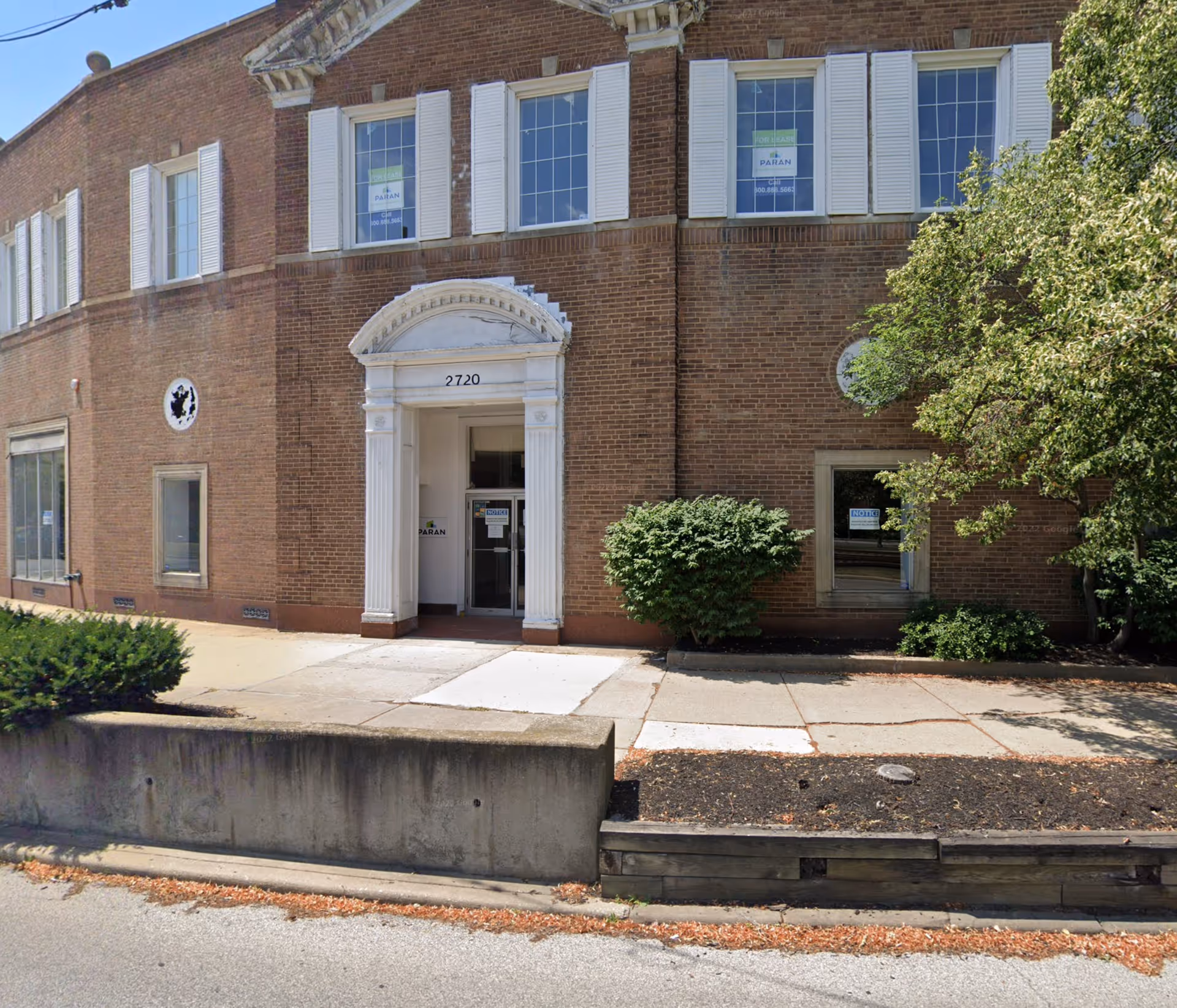 Brick building with white columns and a glass entrance labeled 2720.