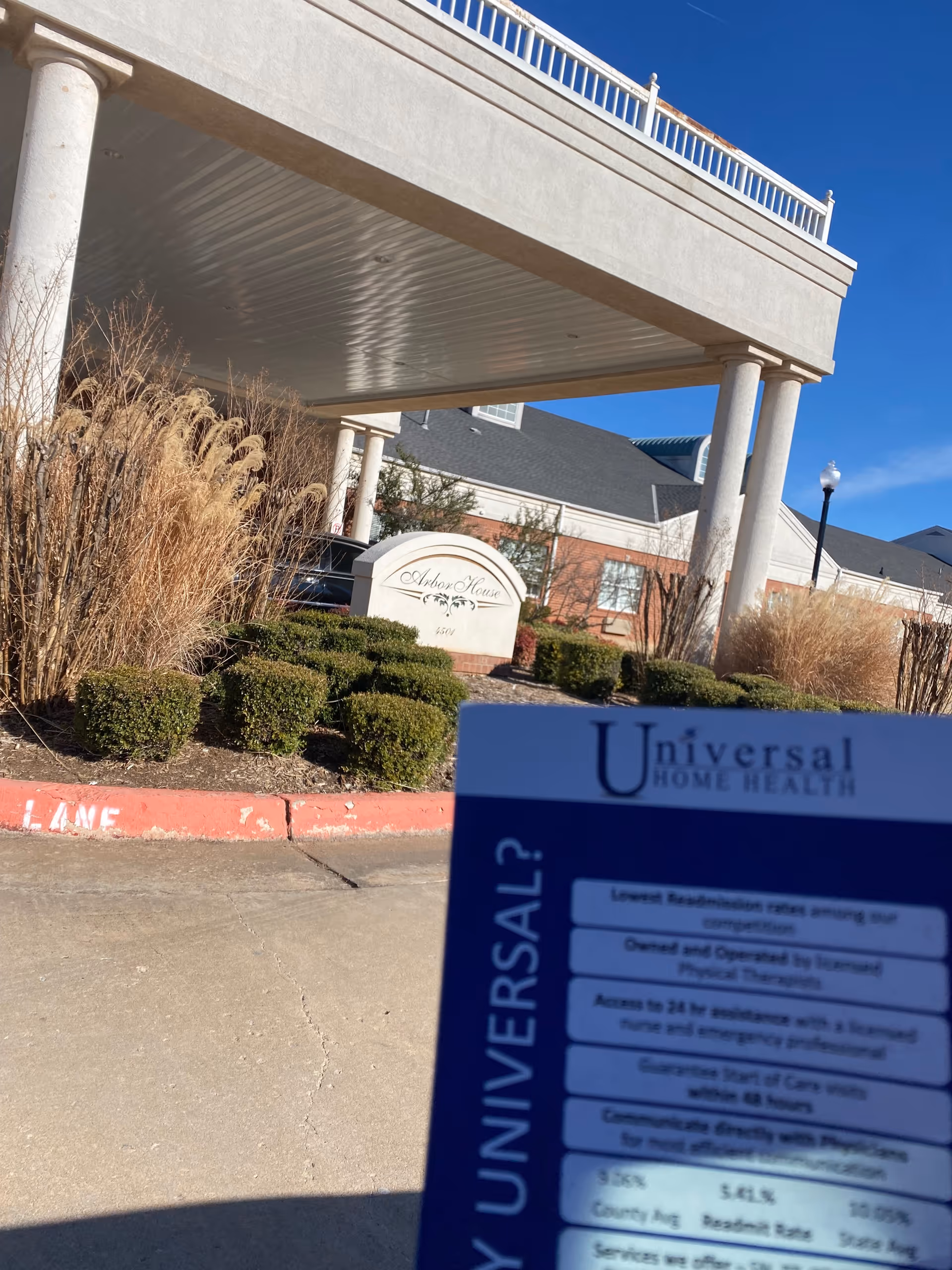 Exterior view of Universal Home Health facility entrance with columns and blue sky.