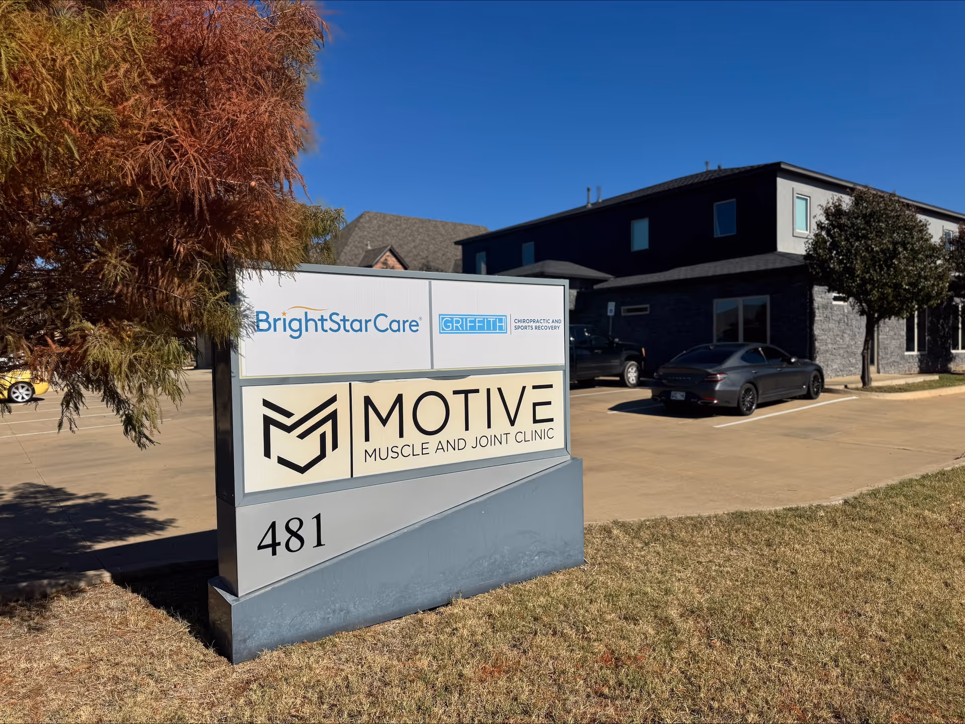 Exterior view of a BrightStar Care building with a large sign and parked cars.
