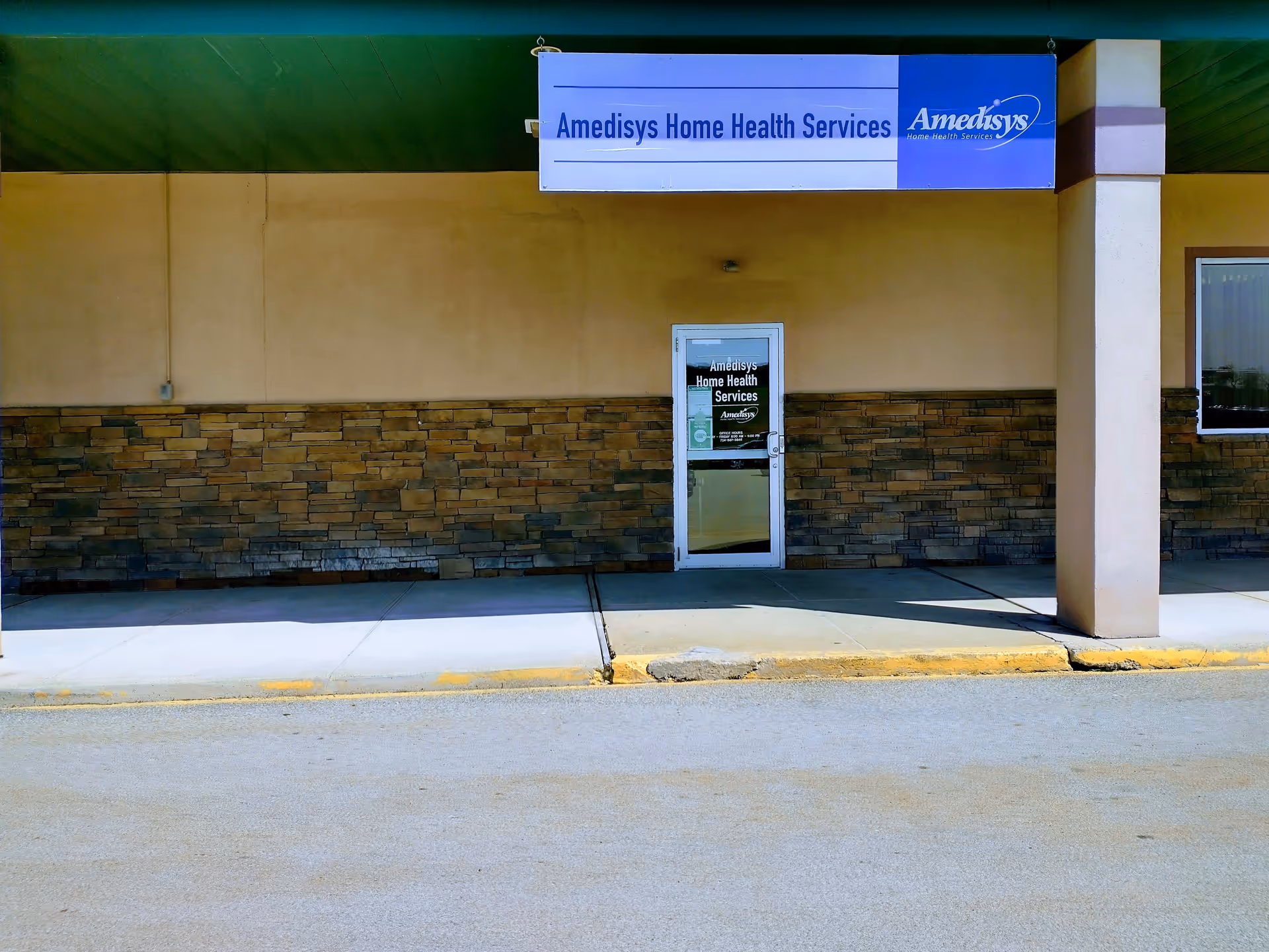 Exterior of a tan building with stone veneer, Amedisys Home Health Services sign, and a door.