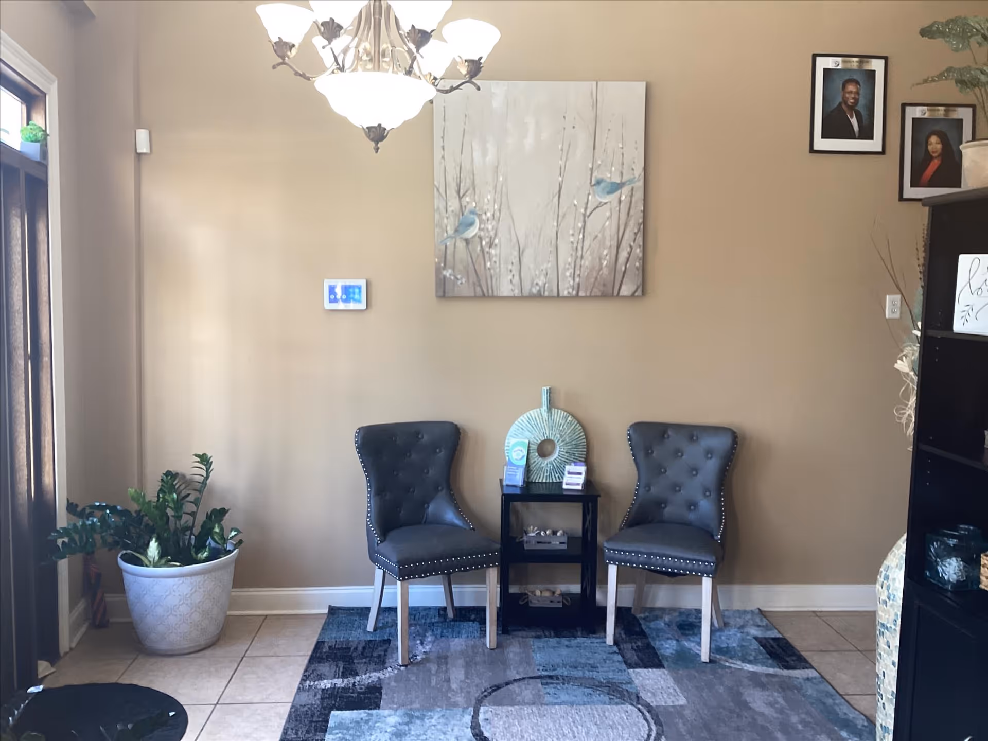 Two tufted chairs flank a small table in a neutral lobby area.