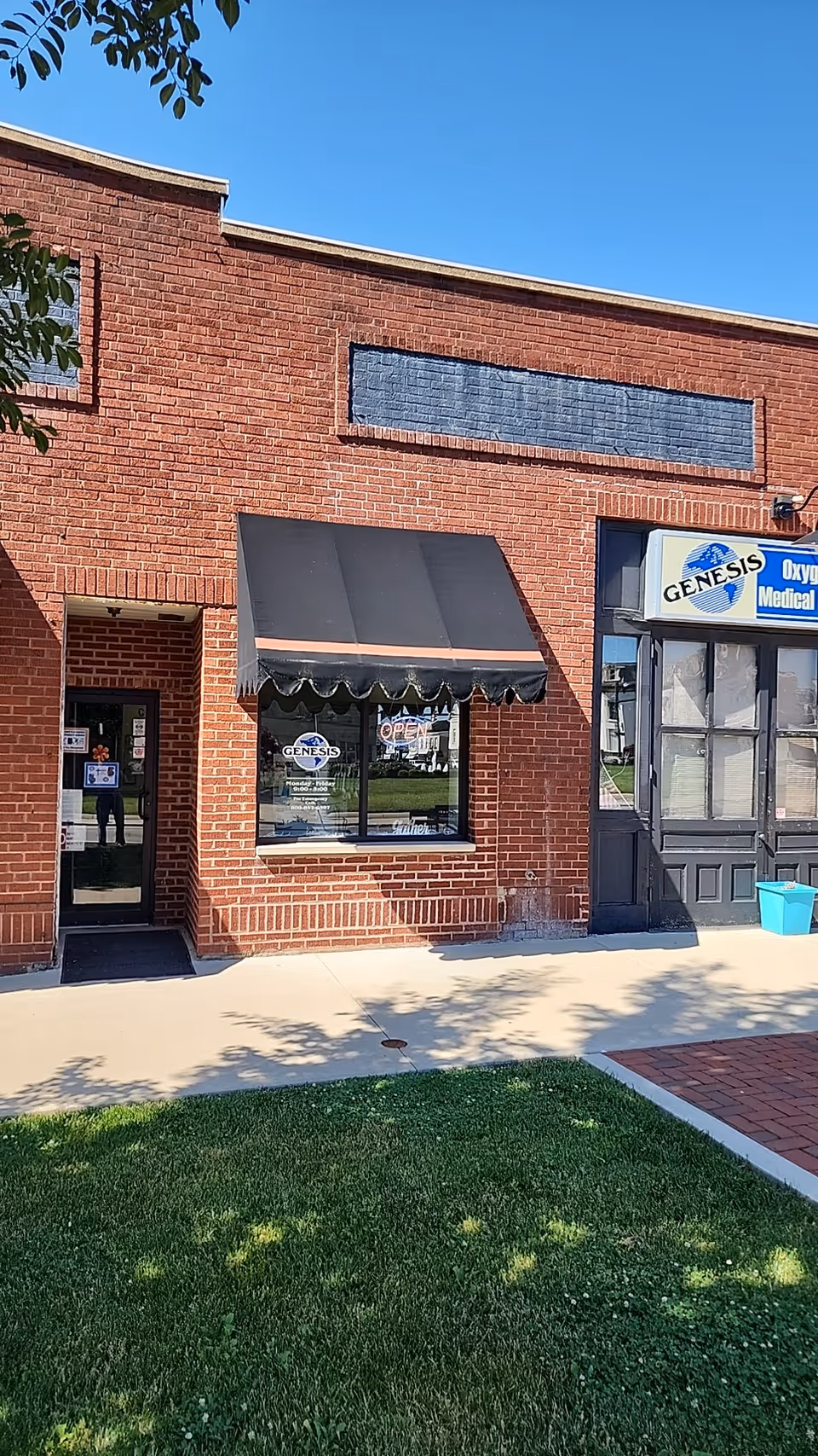 Brick storefront with black awning and Genesis Oxygen & Home Medical Equipment sign