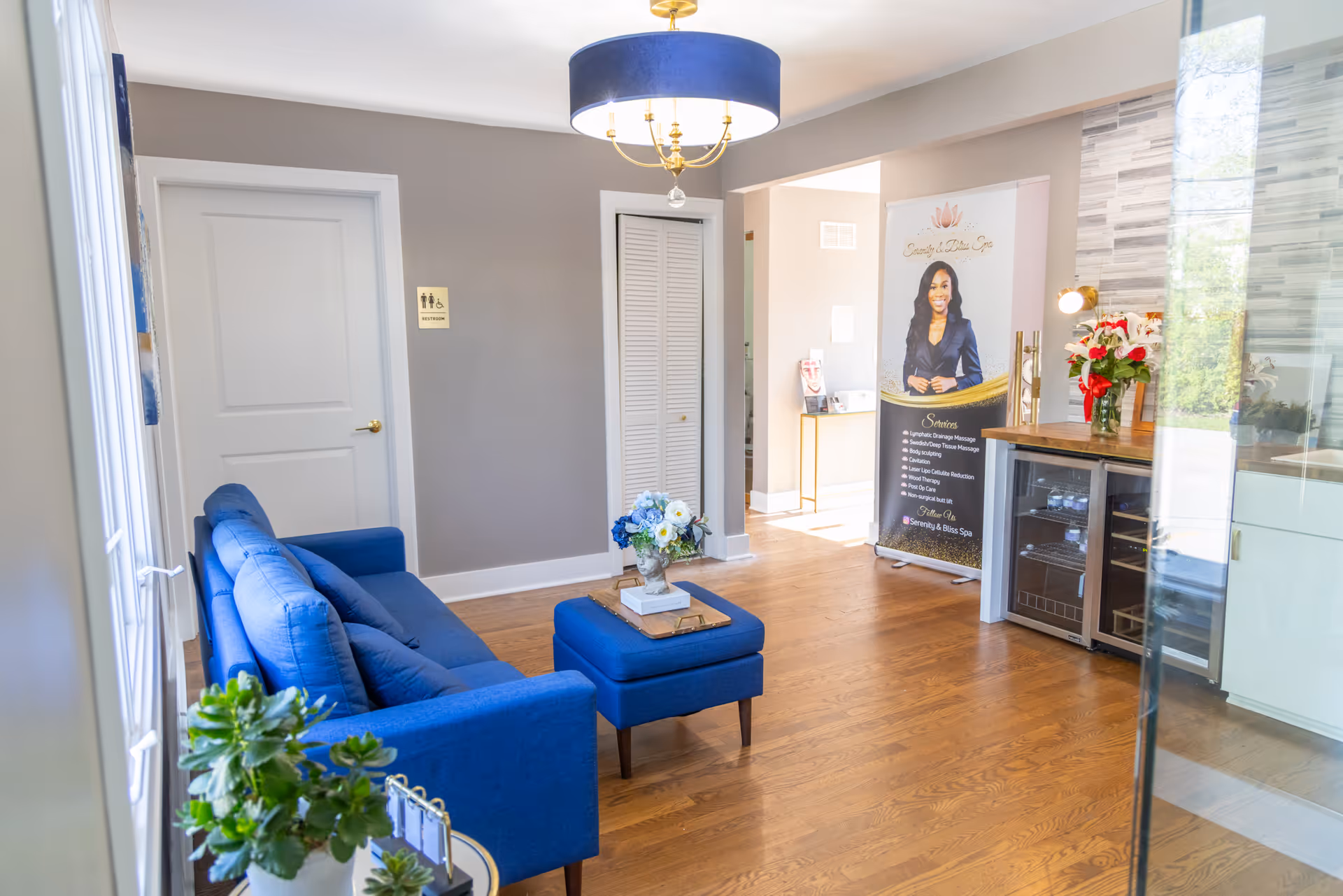 Modern lobby with blue seating, wood floor, and a reception area.