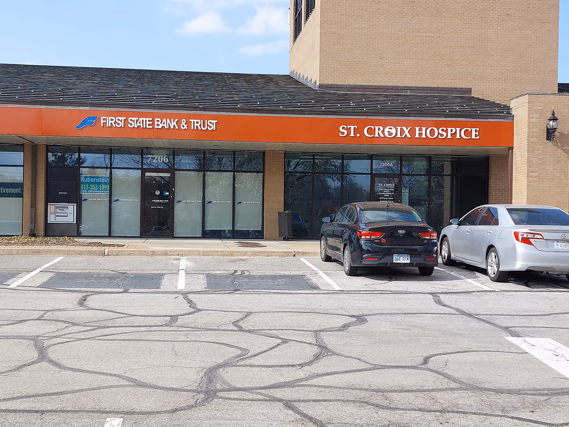 Exterior view of St. Croix Hospice storefront with bank signage and parked cars.