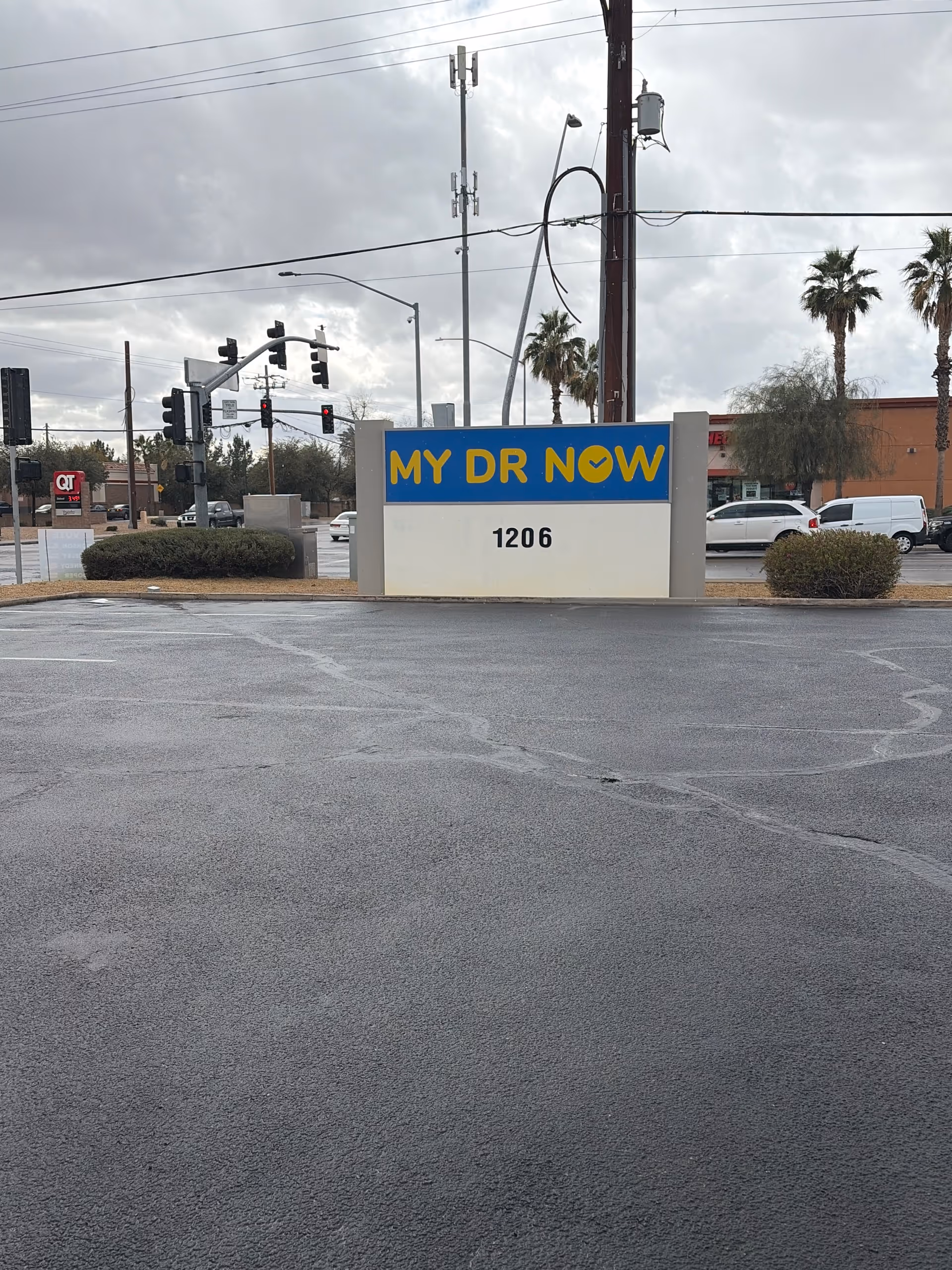 Exterior view of MY DR NOW sign in parking lot with traffic near palm trees