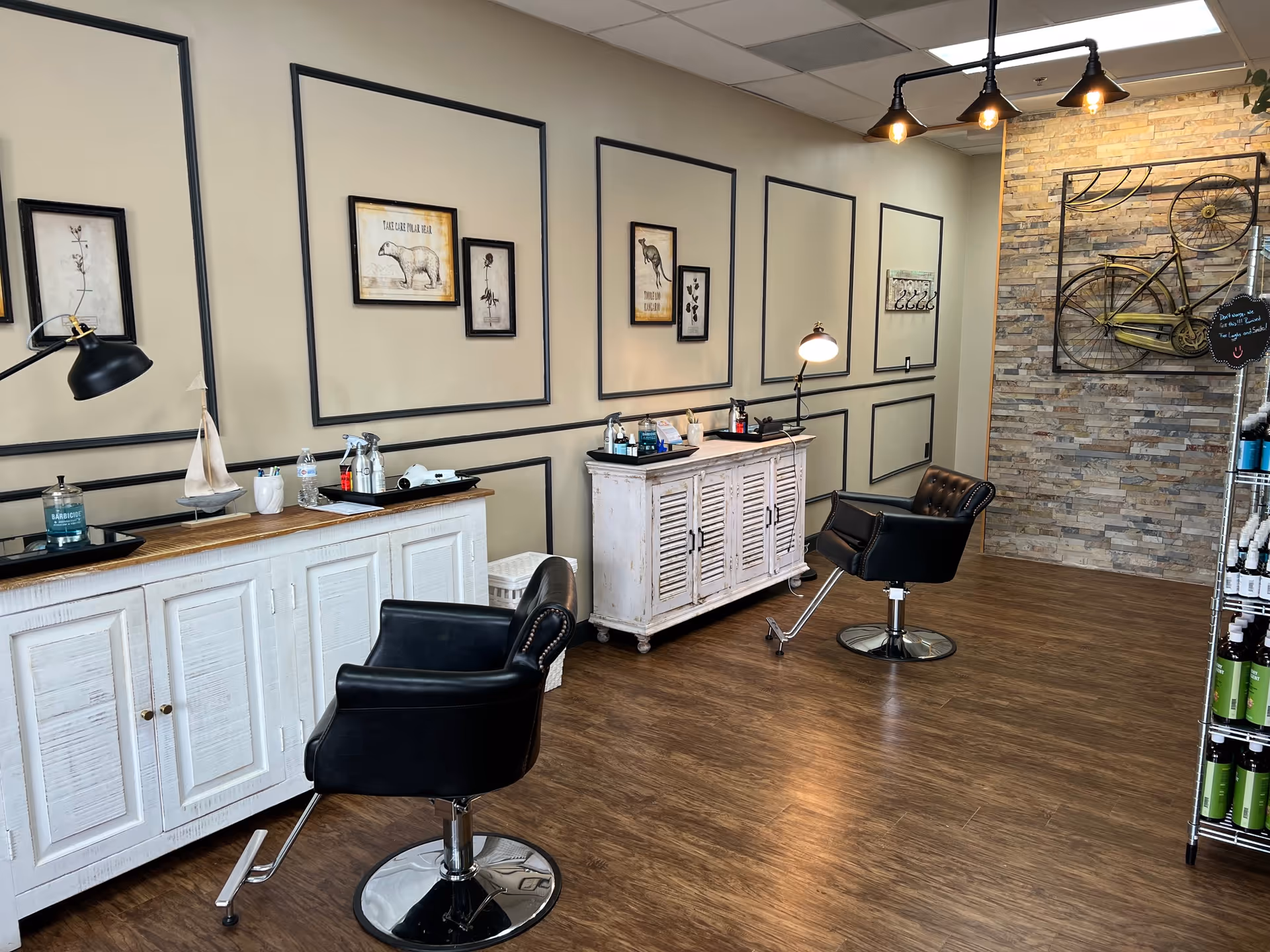 Stylish hair salon interior with chairs, framed art, and a white cabinet.