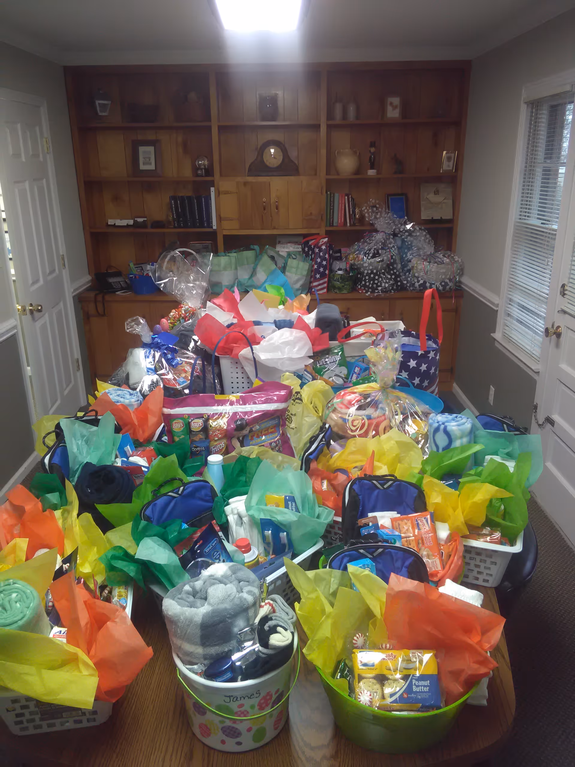 Interior room filled with many colorful gift bags and baskets on a table.
