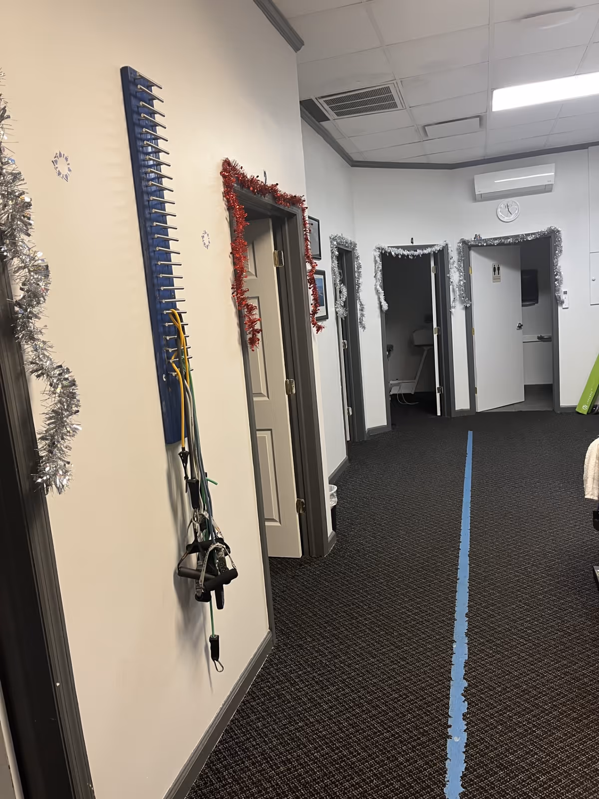 Interior hallway in a senior facility with holiday garlands along doors.
