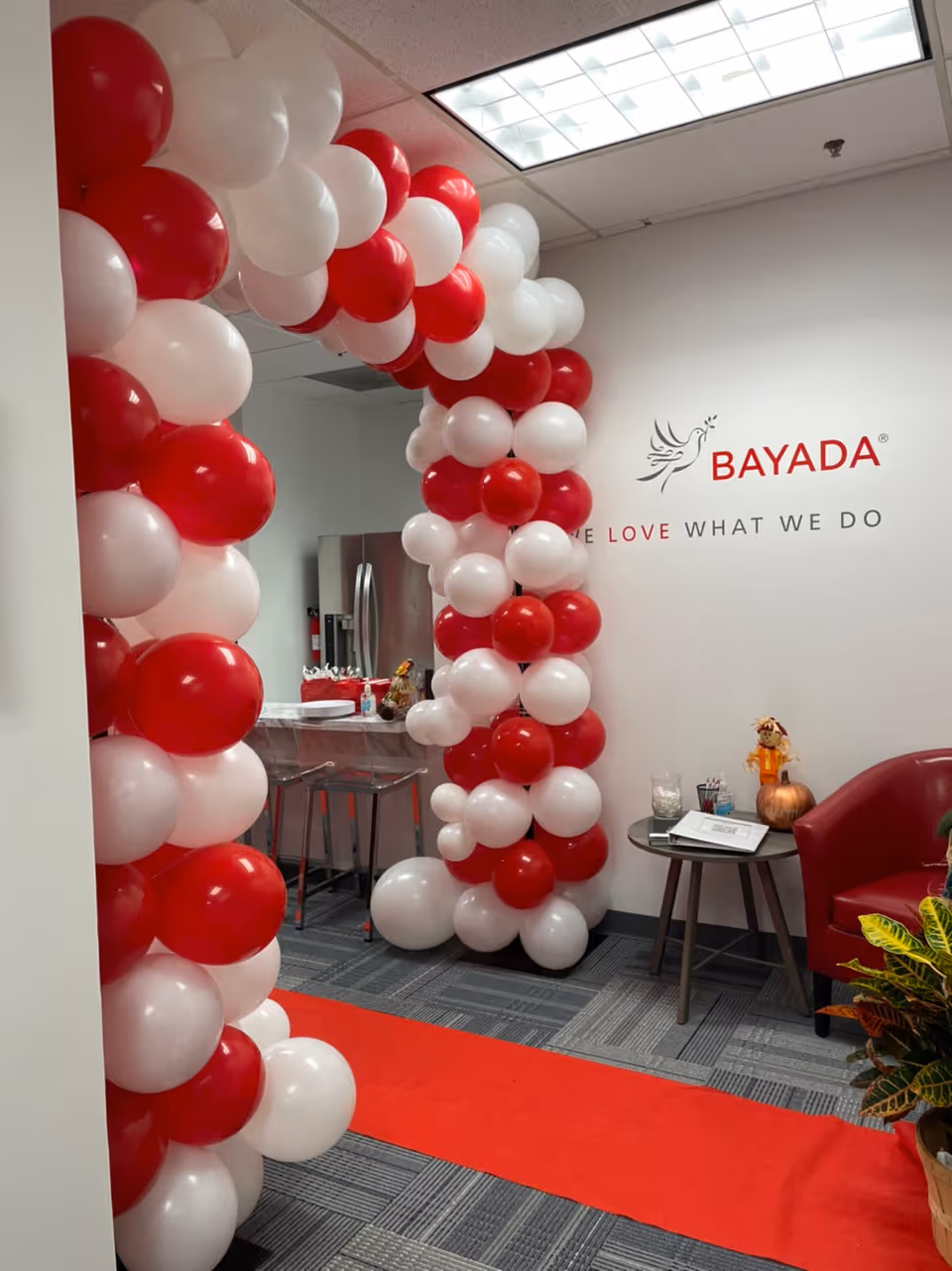 Indoor BAYADA Assistive Care reception area decorated with red and white balloon arch.