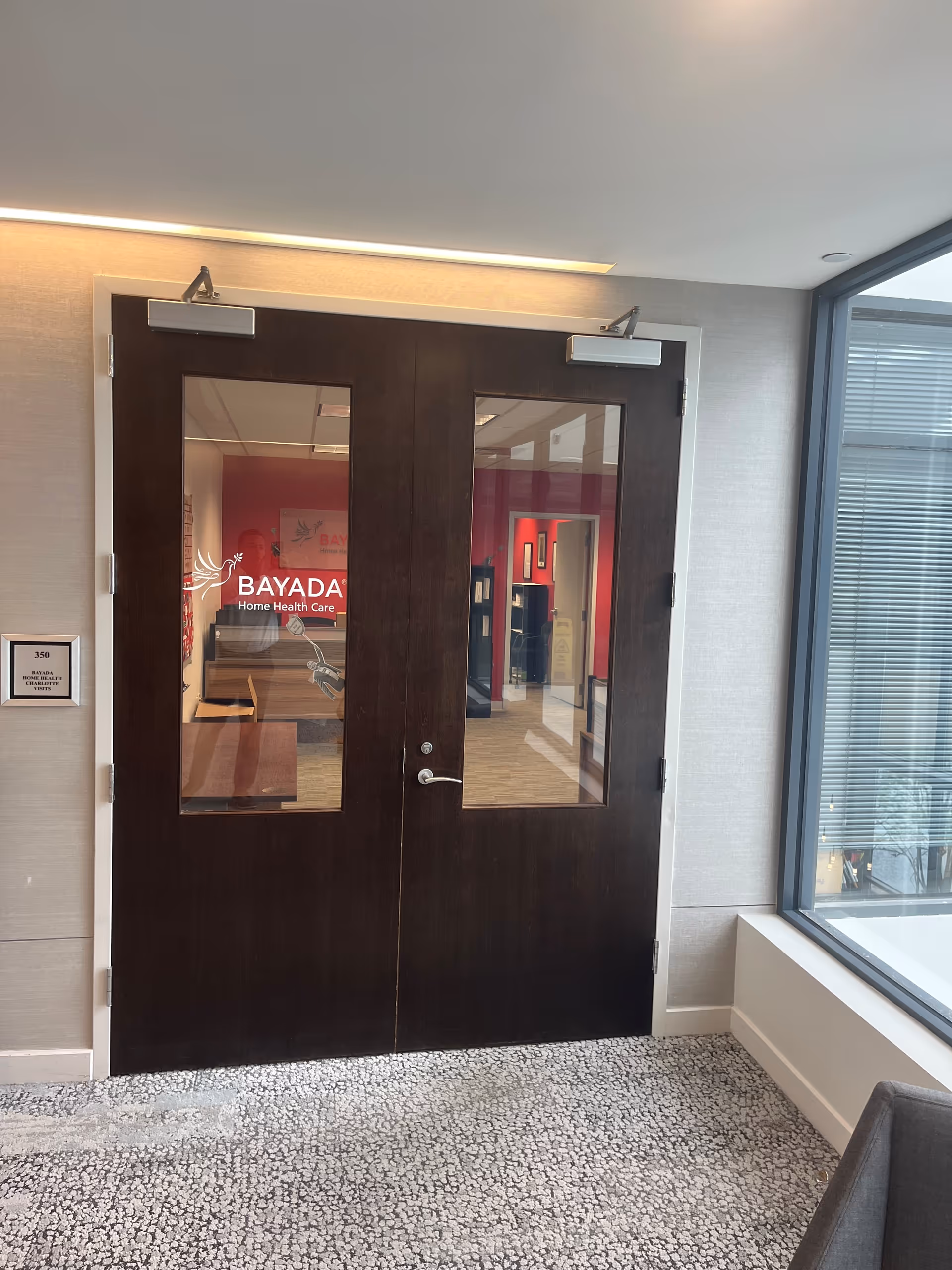 Dark wood double doors with glass panels; BAYADA Home Health Care signage visible inside.