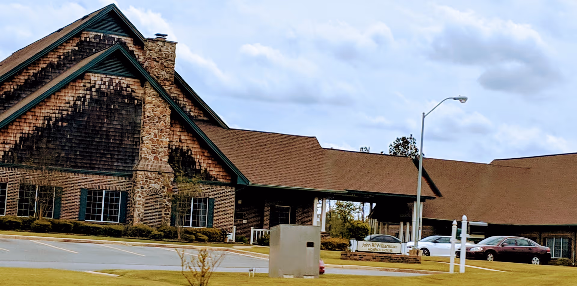 Exterior view of Life Touch Hospice building with parking lot and entrance.