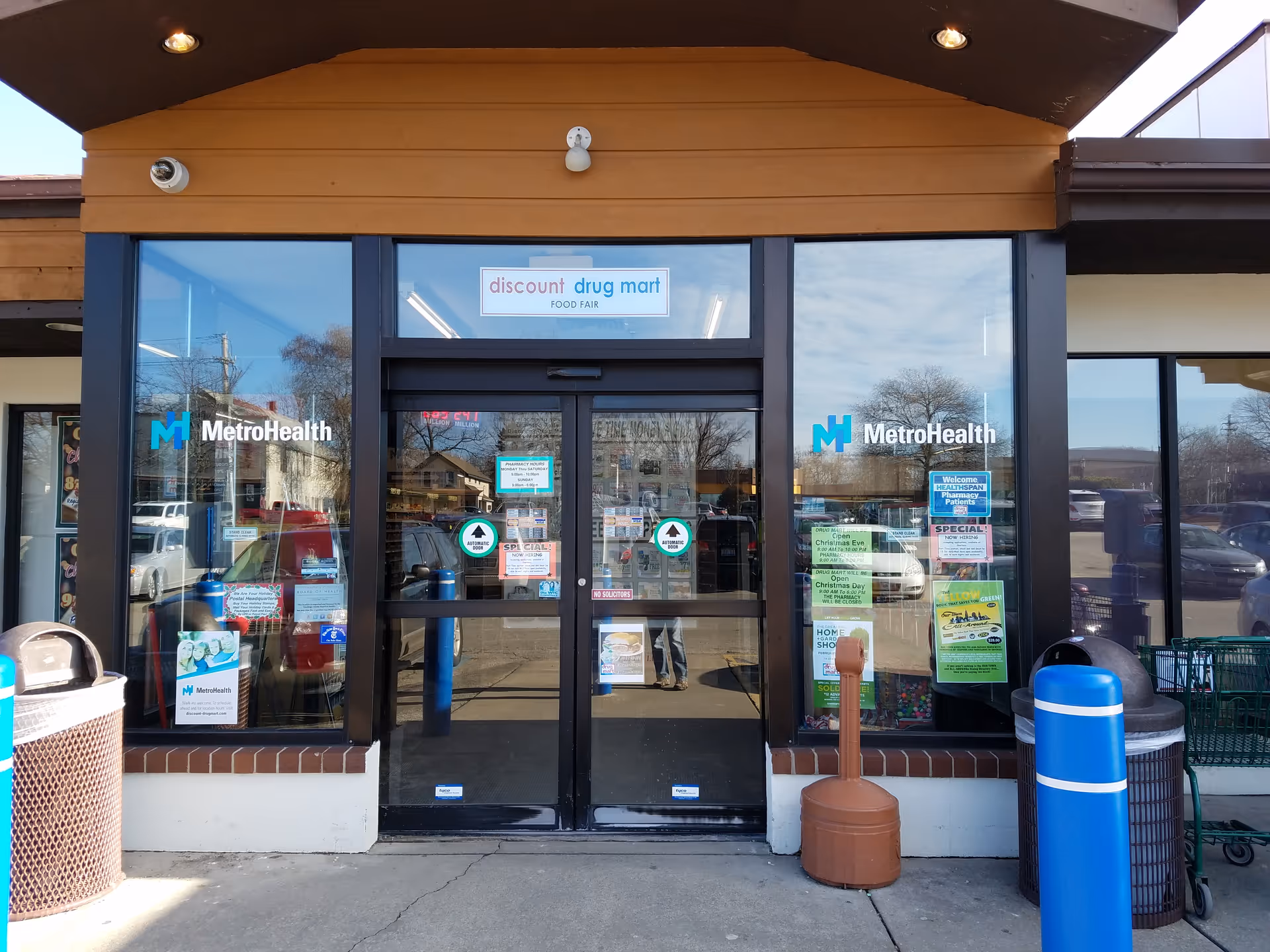 Storefront of Discount Drug Mart with glass doors and MetroHealth logos on windows.
