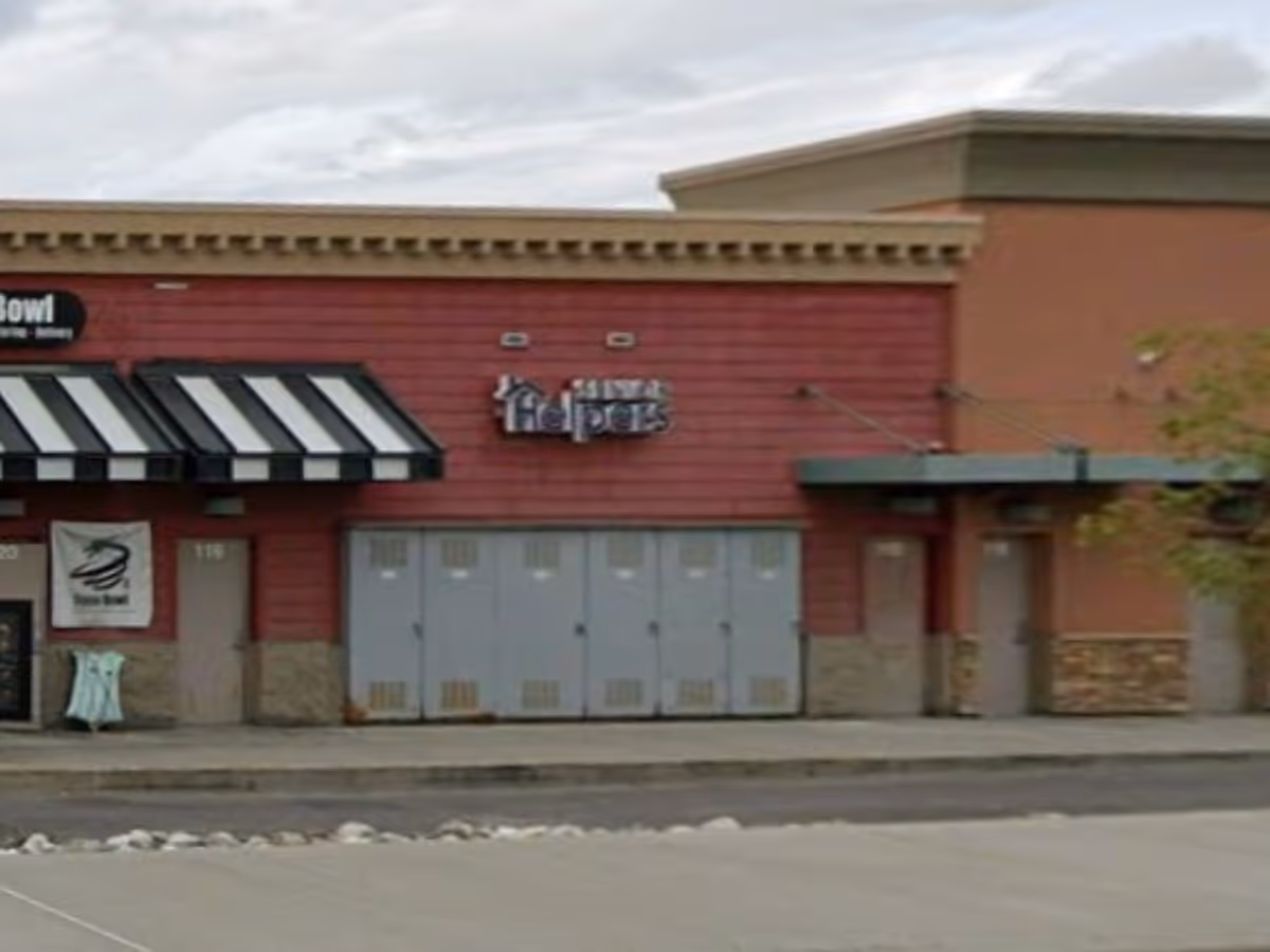 Exterior view of a Senior Helpers building with red siding and gray doors.