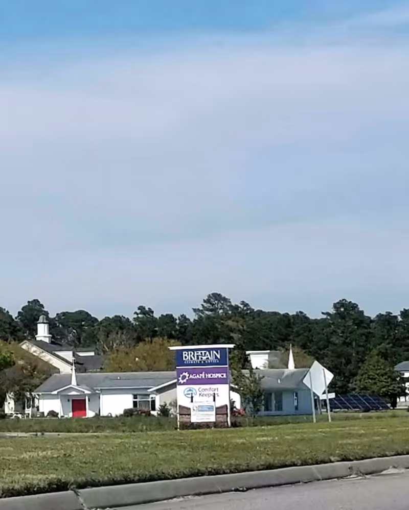 Front exterior of a senior care facility with Comfort Keepers signage along the road.