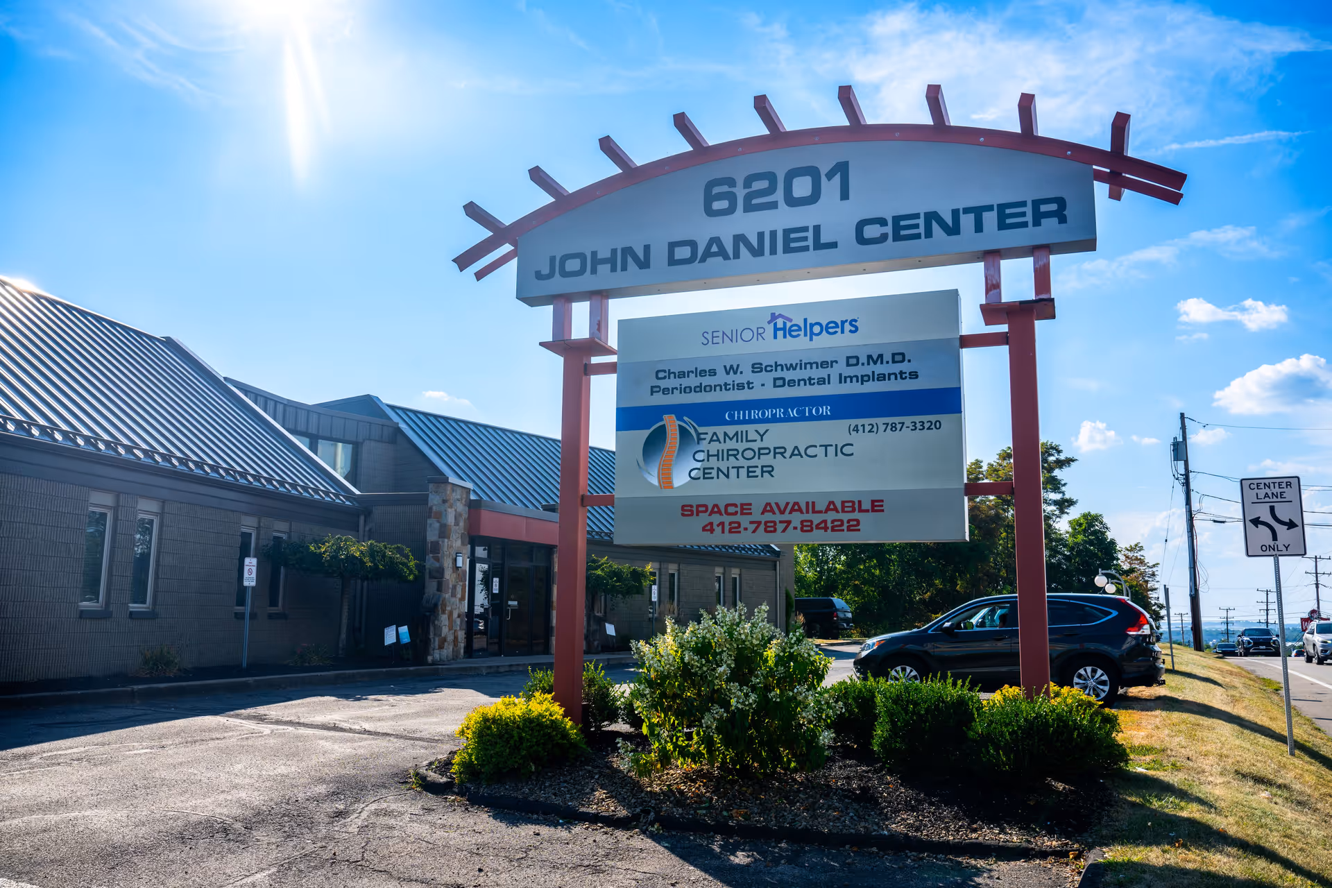 Exterior view of a Senior Helpers facility with a large sign and parking area.