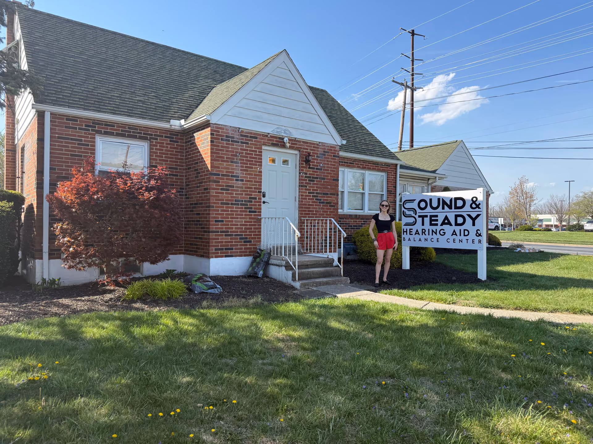 Front view of Sound and Steady Hearing Aids facility with a person outside.