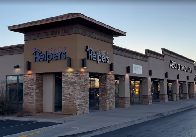 Exterior of a shopping center with Senior Helpers signage and stone column accents.